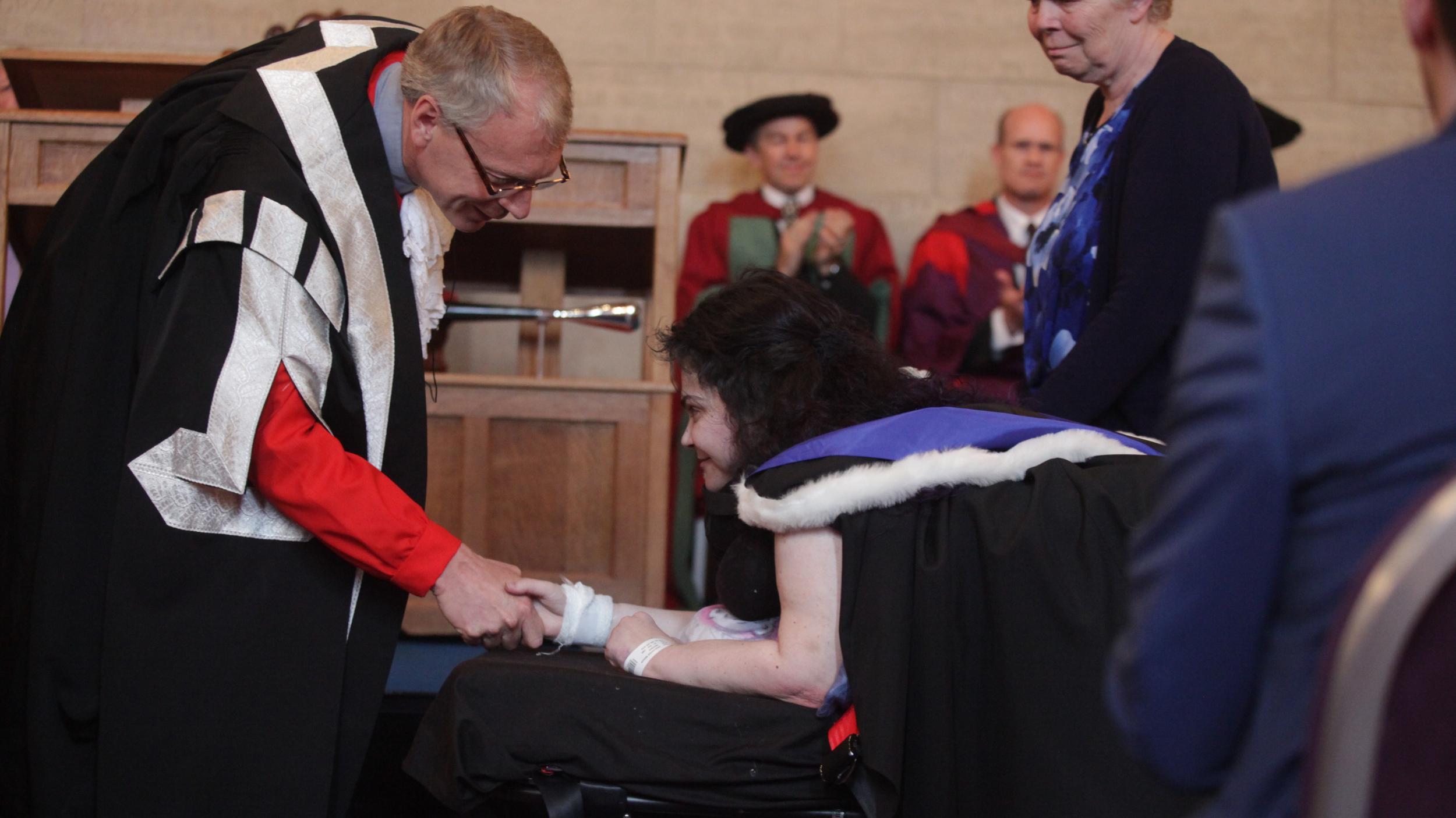 The student, pictured, collects her degree along with her classmates