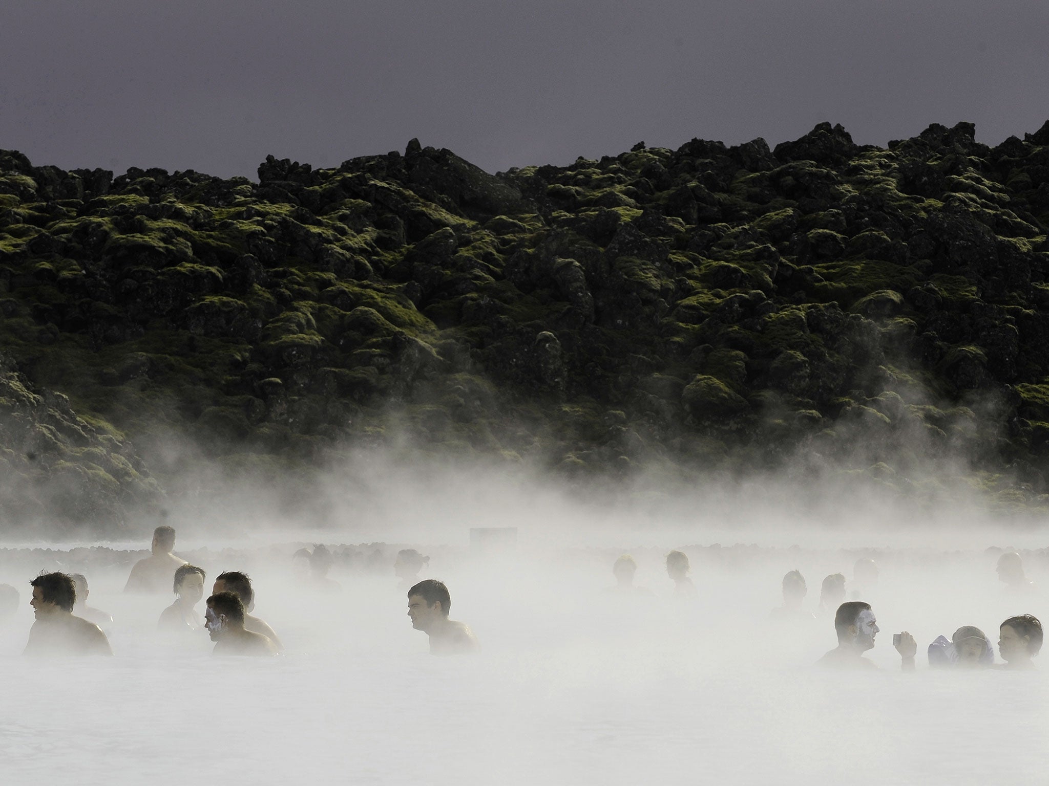 Tourists stand in the Blue Lagoon outside Reykjavik