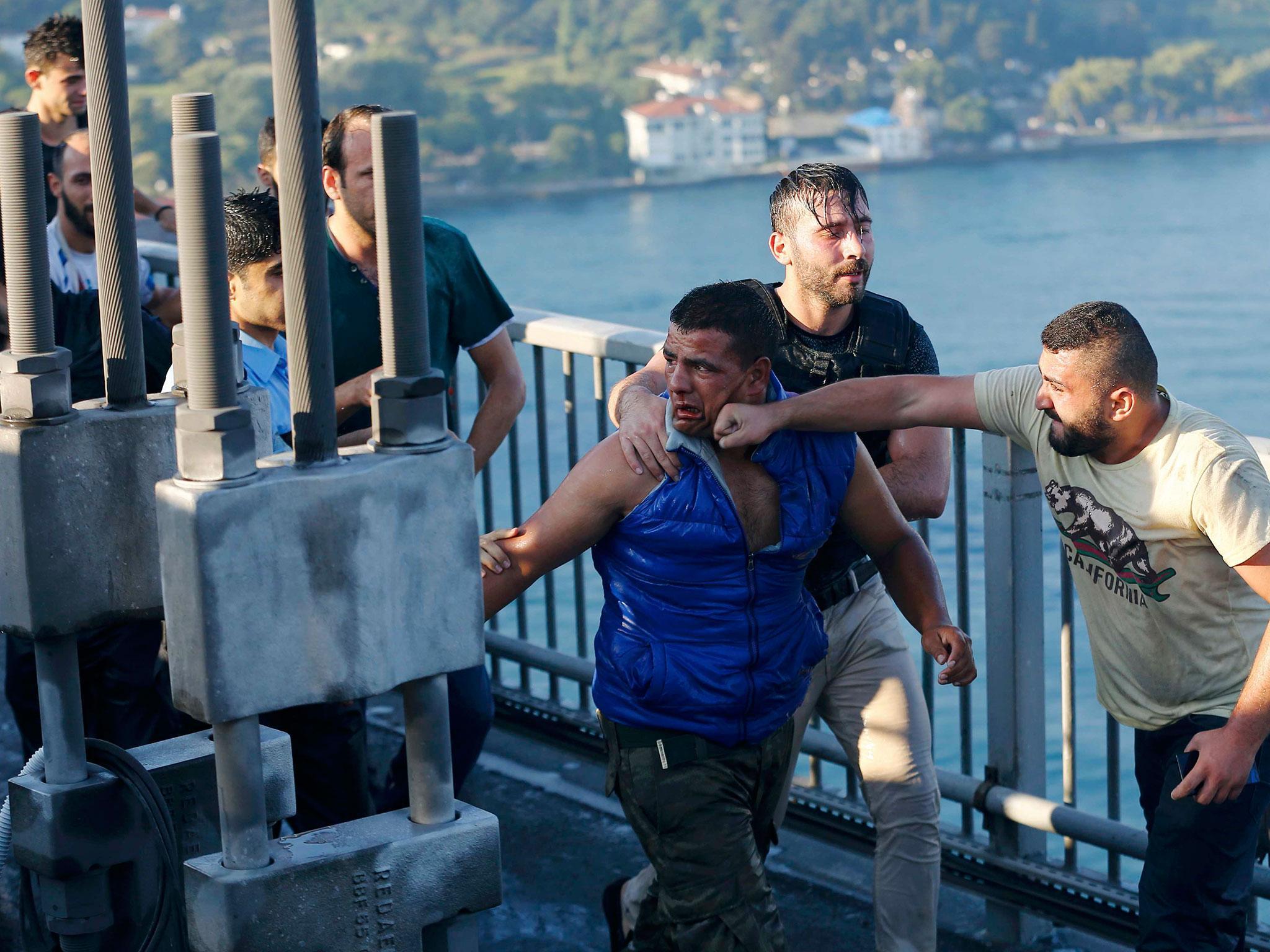 A civilian beats a soldier after troops involved in the coup surrendered on the Bosphorus Bridge in Istanbul, Turkey, 16 July, 2016