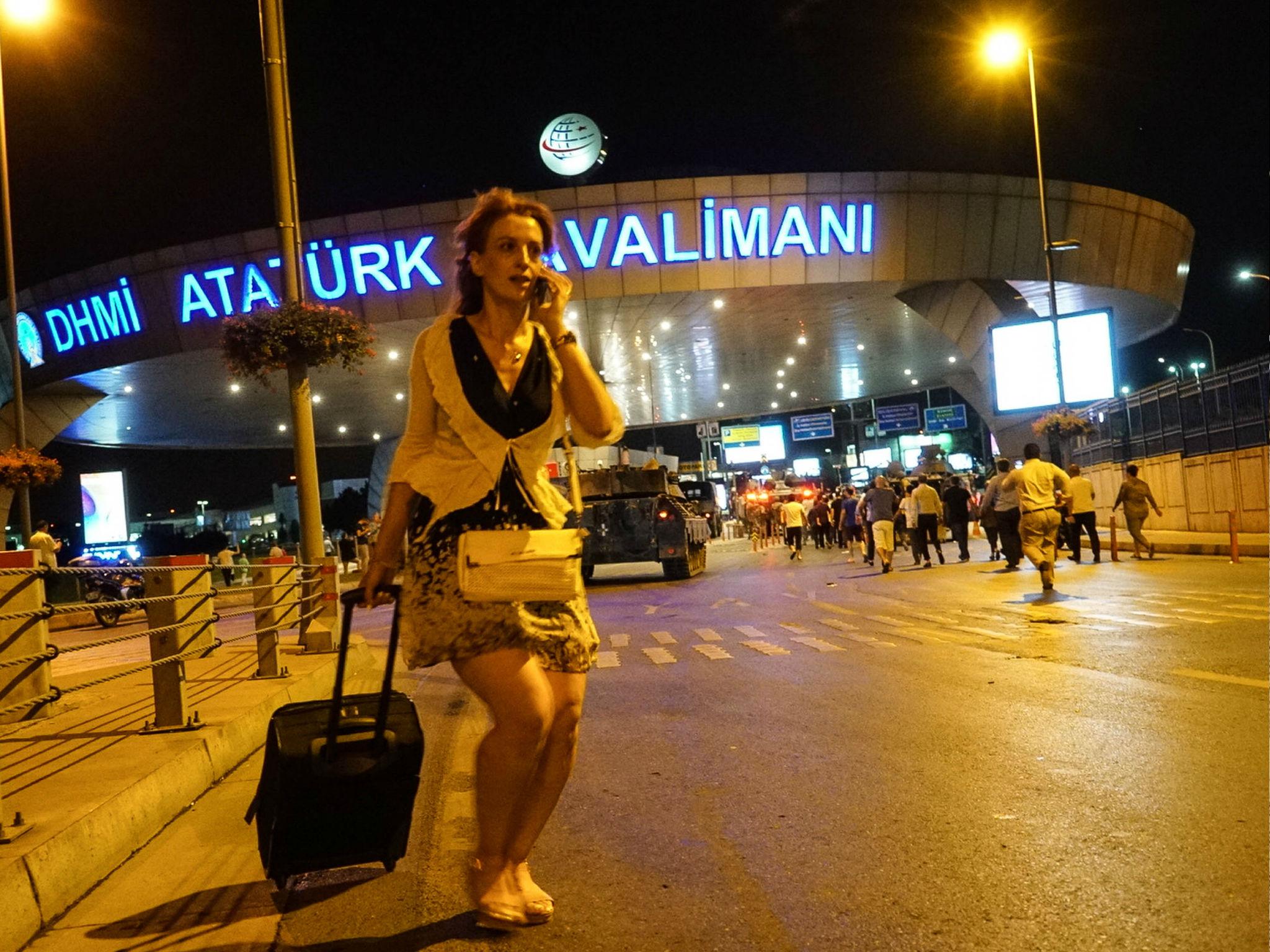 A passenger walks as Turkish army's tanks enter the Ataturk Airport on July 16, 2016 in Istanbul, Turkey.