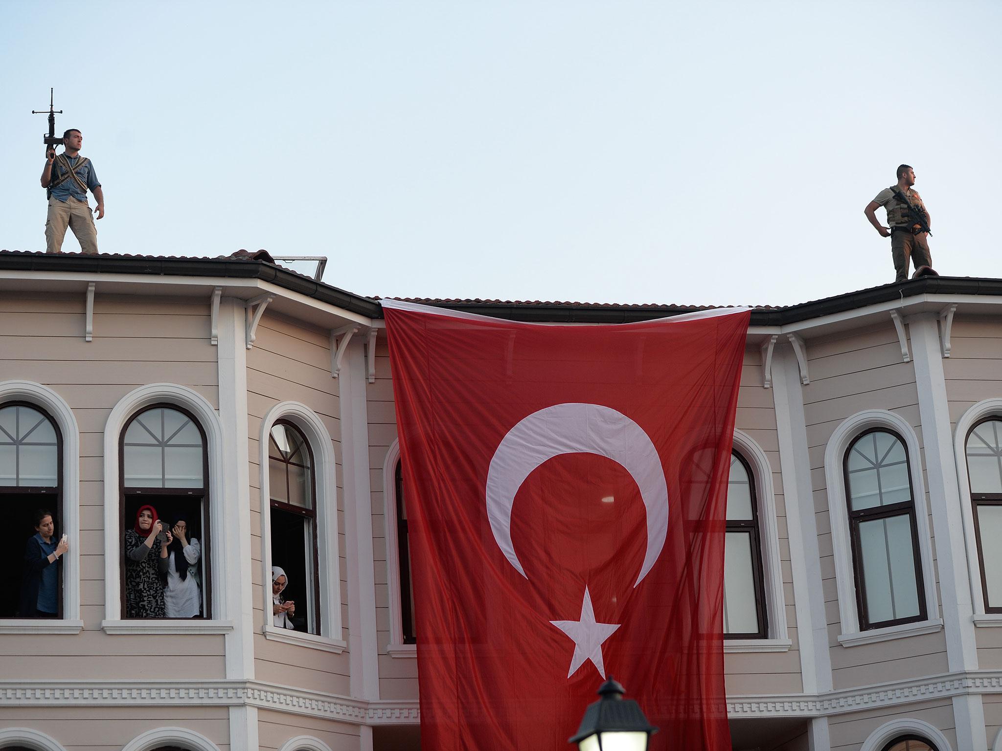 Security officers guard secure the area as President Erdogan arrives to give a speech to supporters following a failed coup attempt