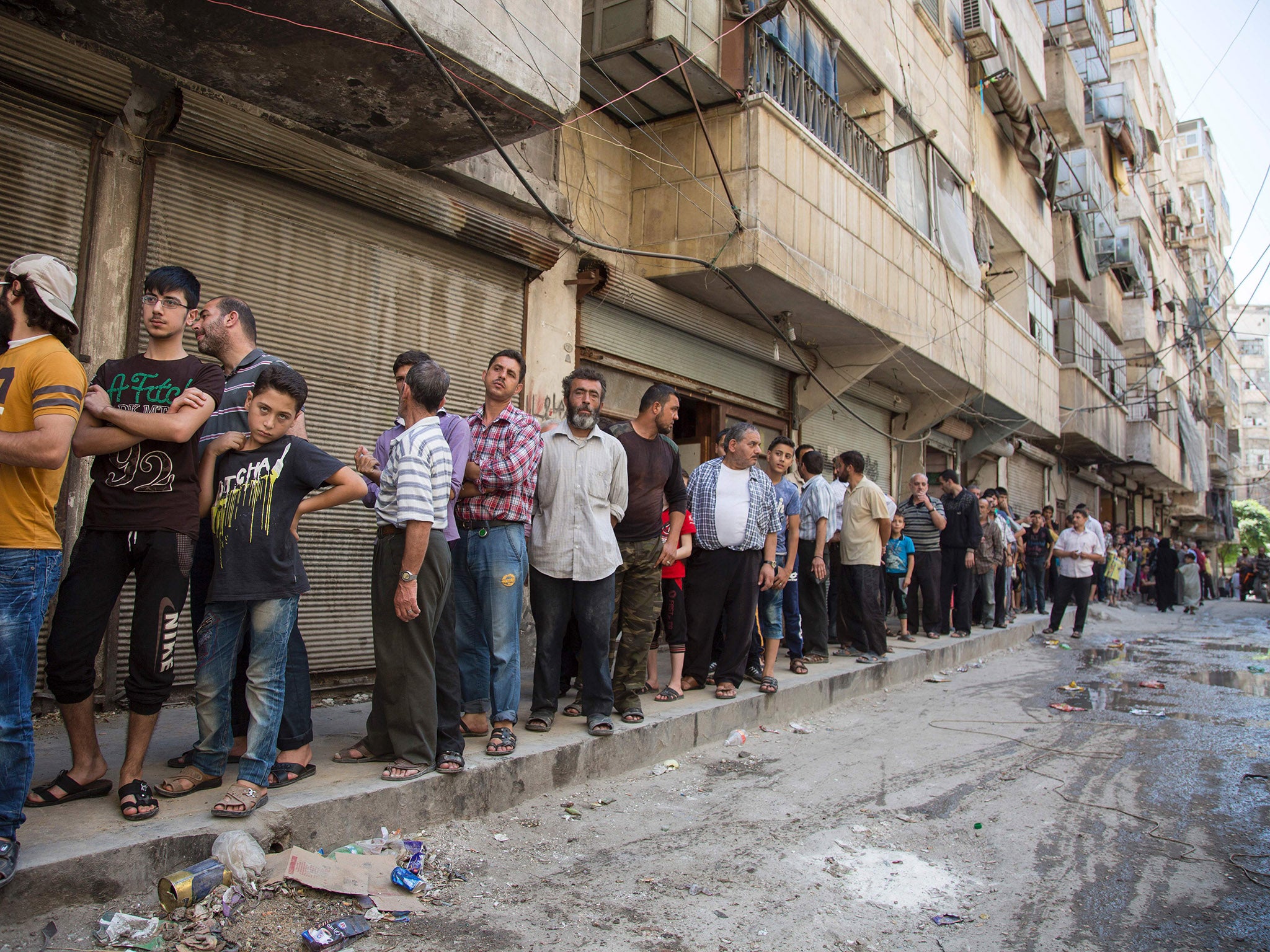 Syrians queue up to buy bread in a rebel held area of Aleppo on July 12, 2016.