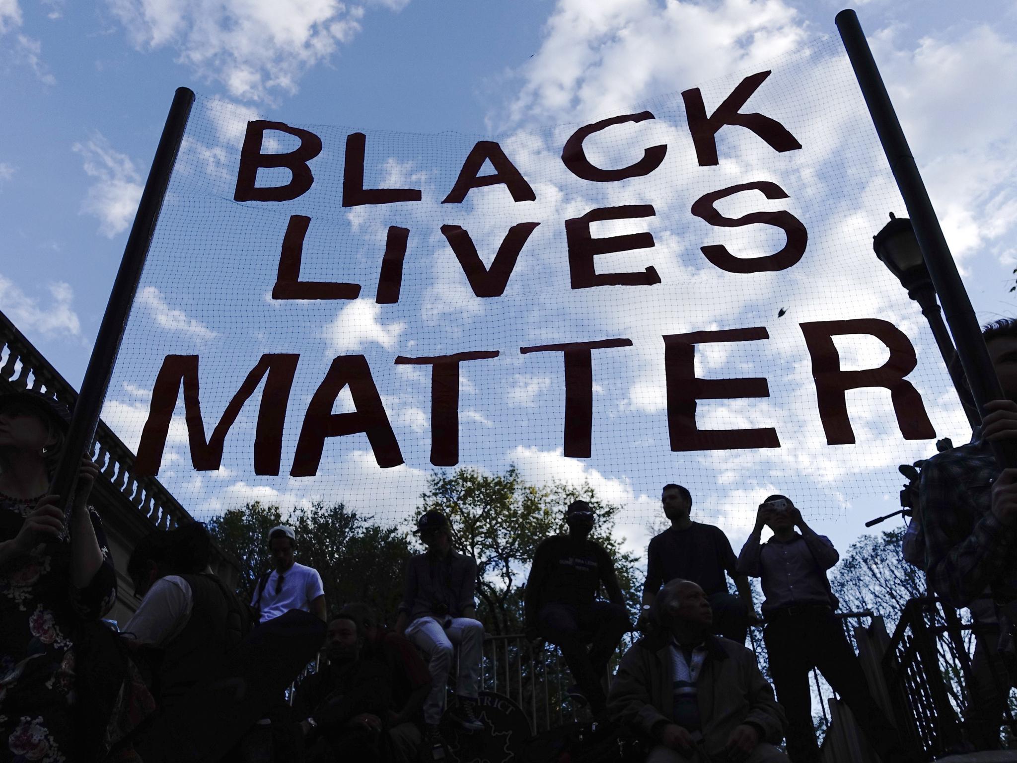 Protesters hold up a Black Lives Matter banner