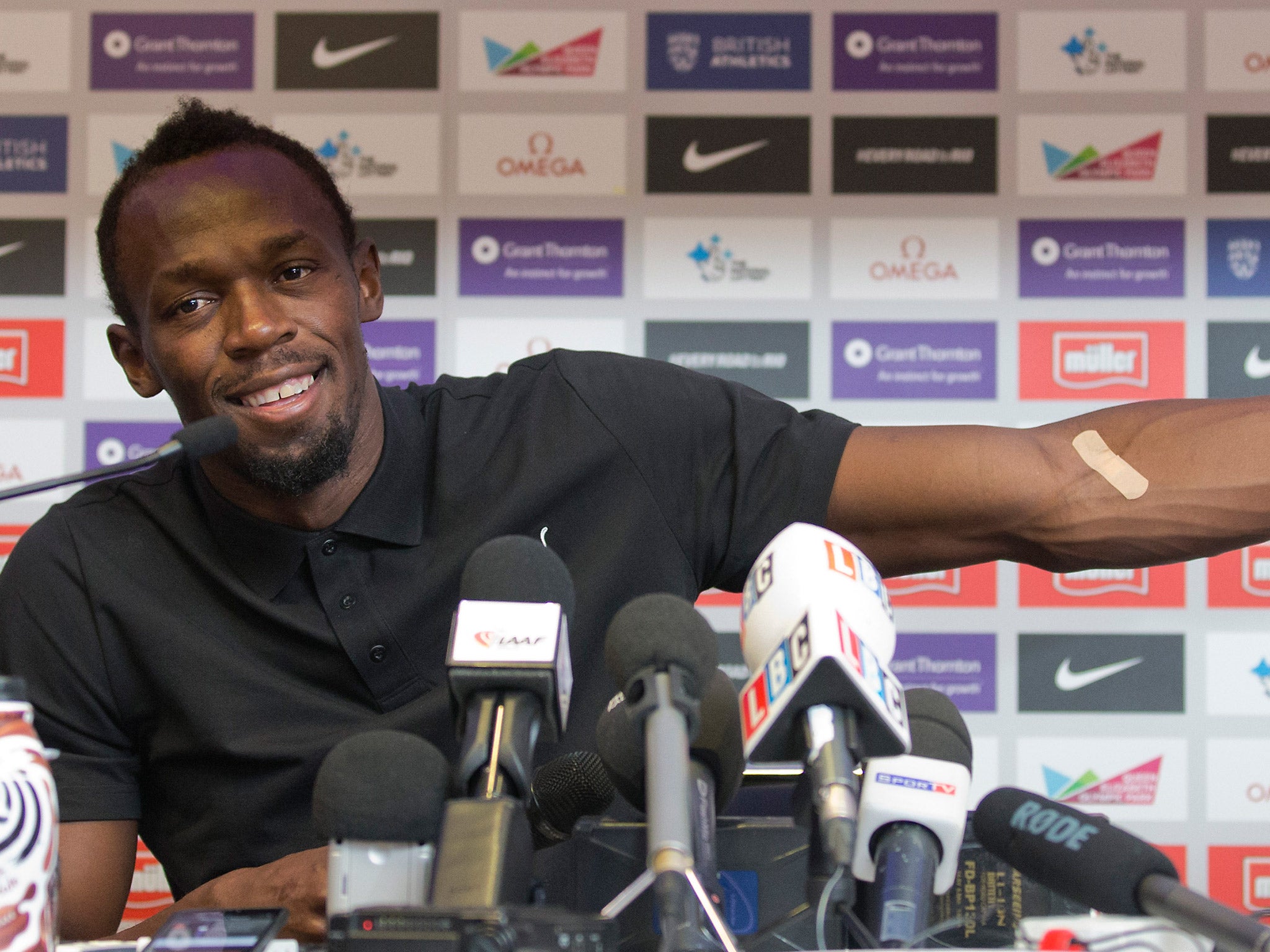 Usain Bolt shows off a plaster from a recent drug test