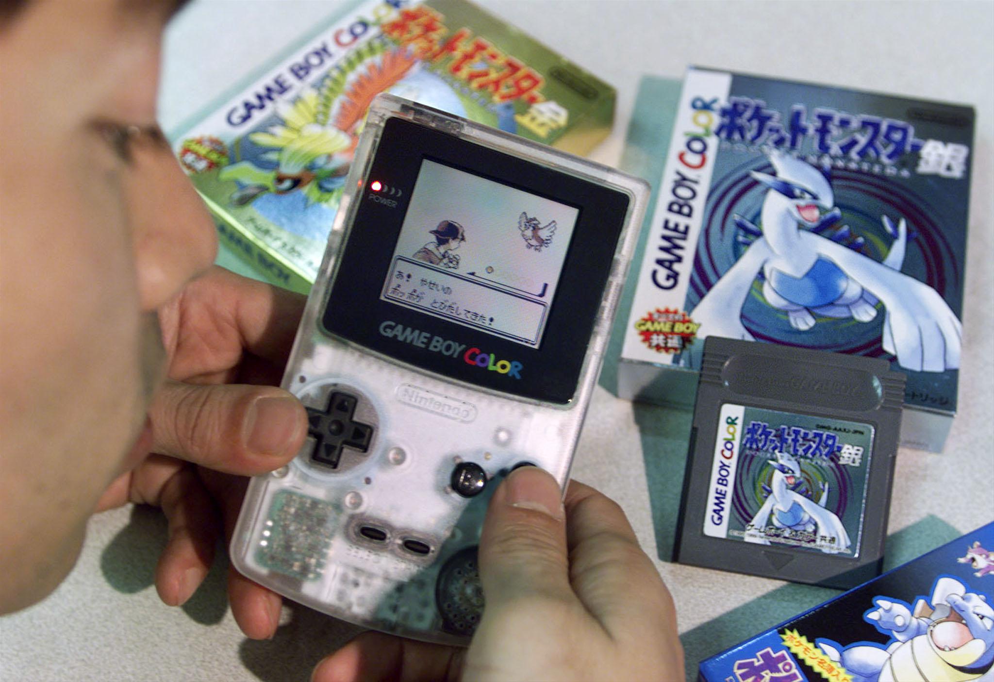 Nintendo Co employee Toru Kusakabe displays the game-maker's newly-launched Pokemon, or pocket monster video game software