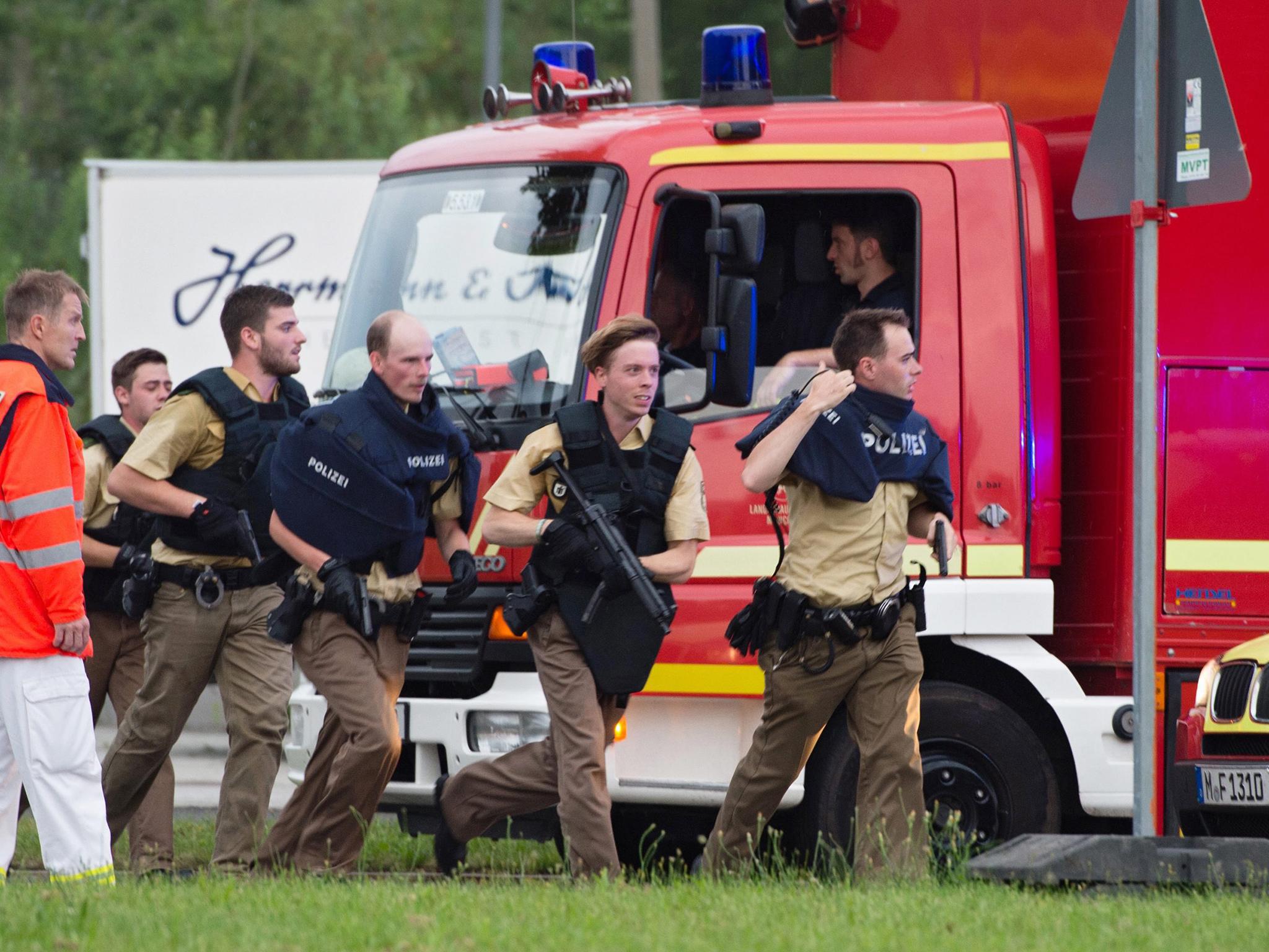 Police officers rush to the scene at a shopping centre in which a shooting was reported, Munich, Germany