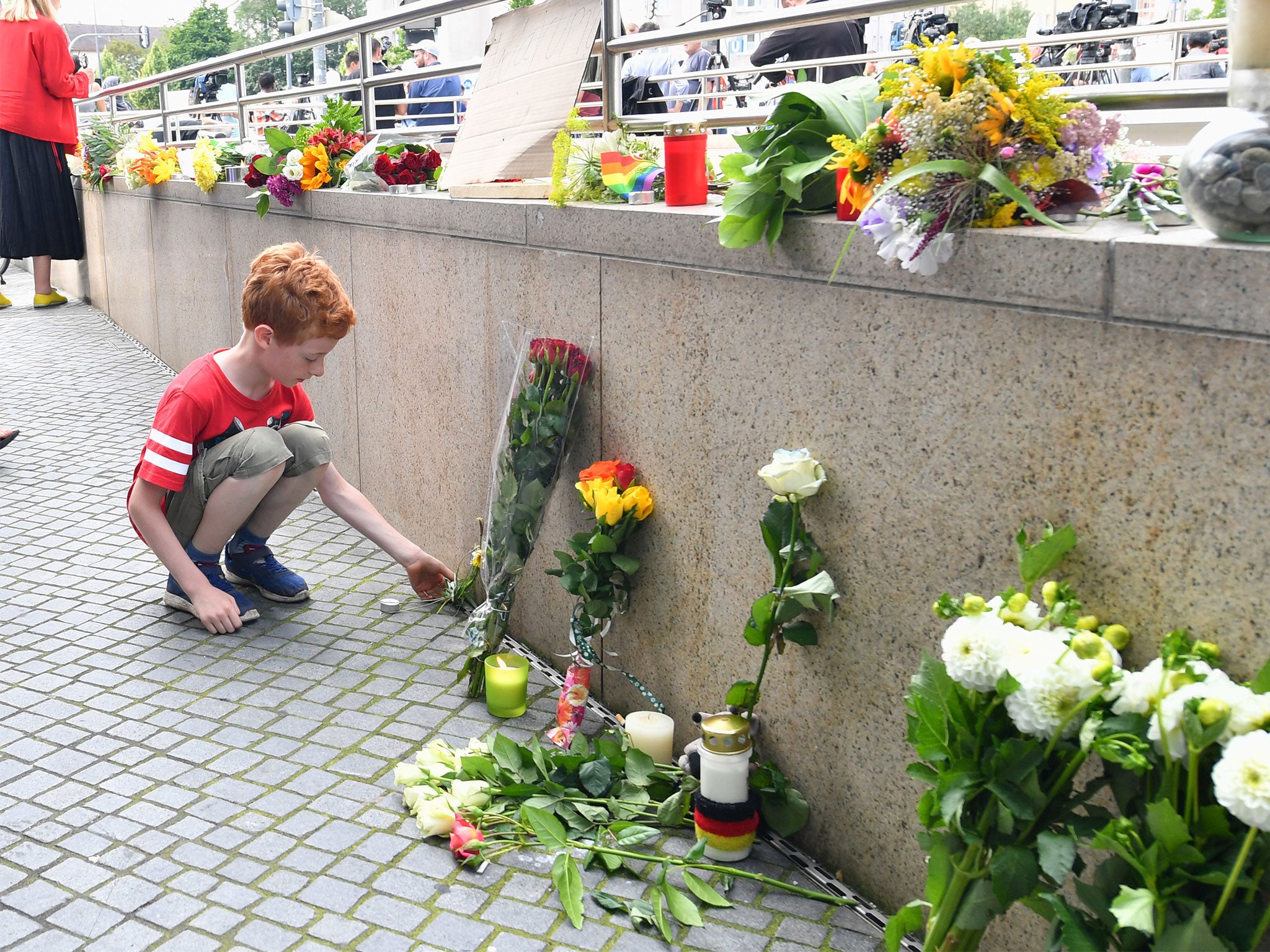 Mourners lay flowers near the OEZ mall where a shooting took place leaving nine people dead