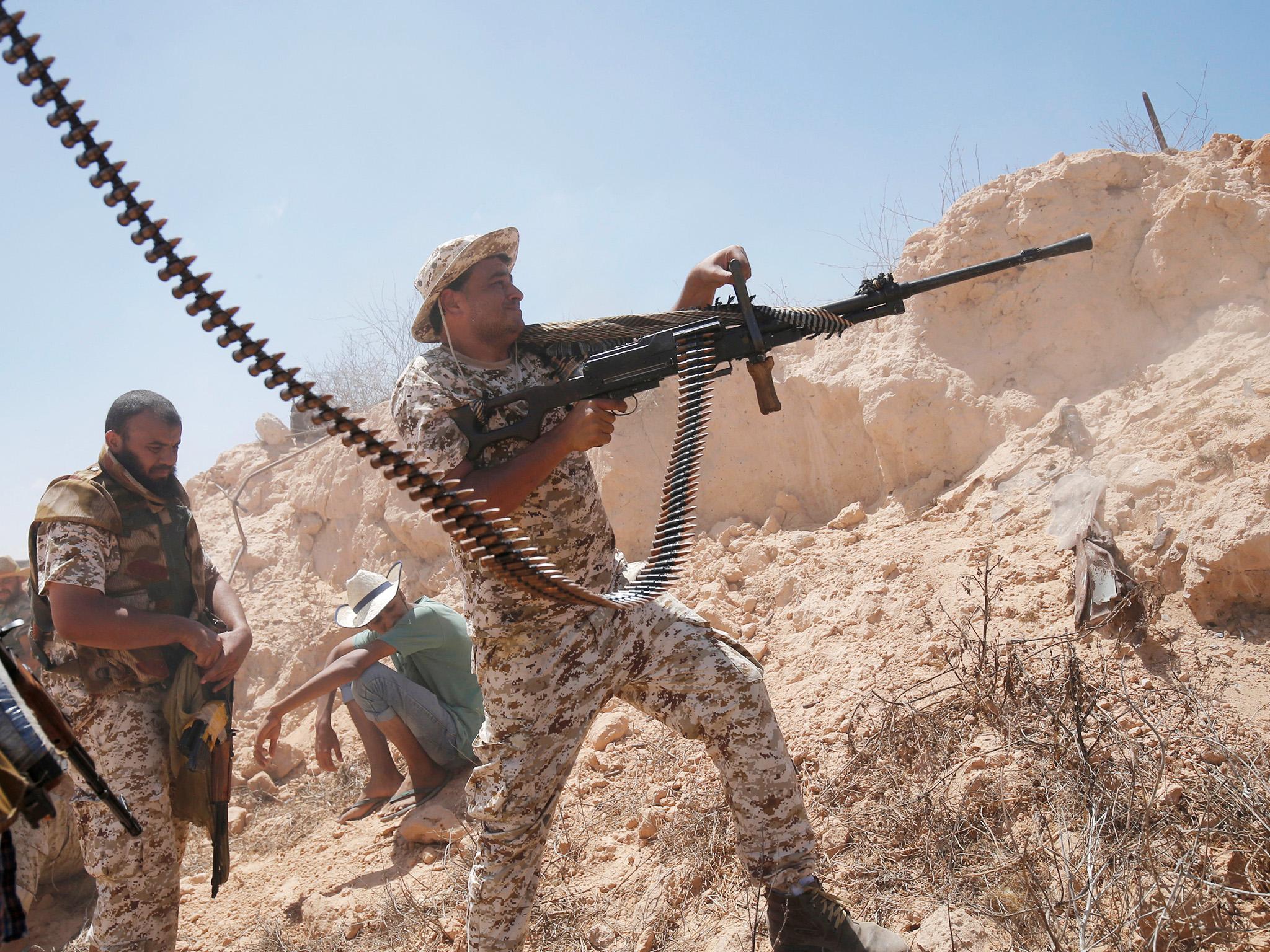 &#13;
A fighter of Libyan forces allied with the UN-backed government fires a weapon during a battle with Isis fighters in Sirte &#13;