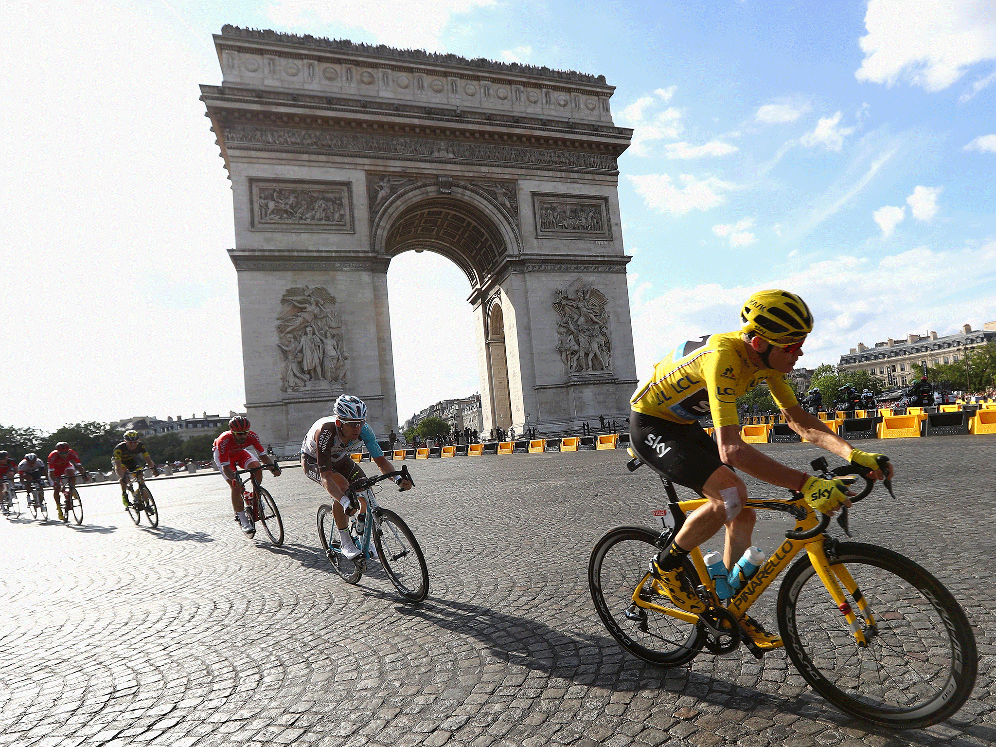 Chris Froome passes the Arc de Triomphe