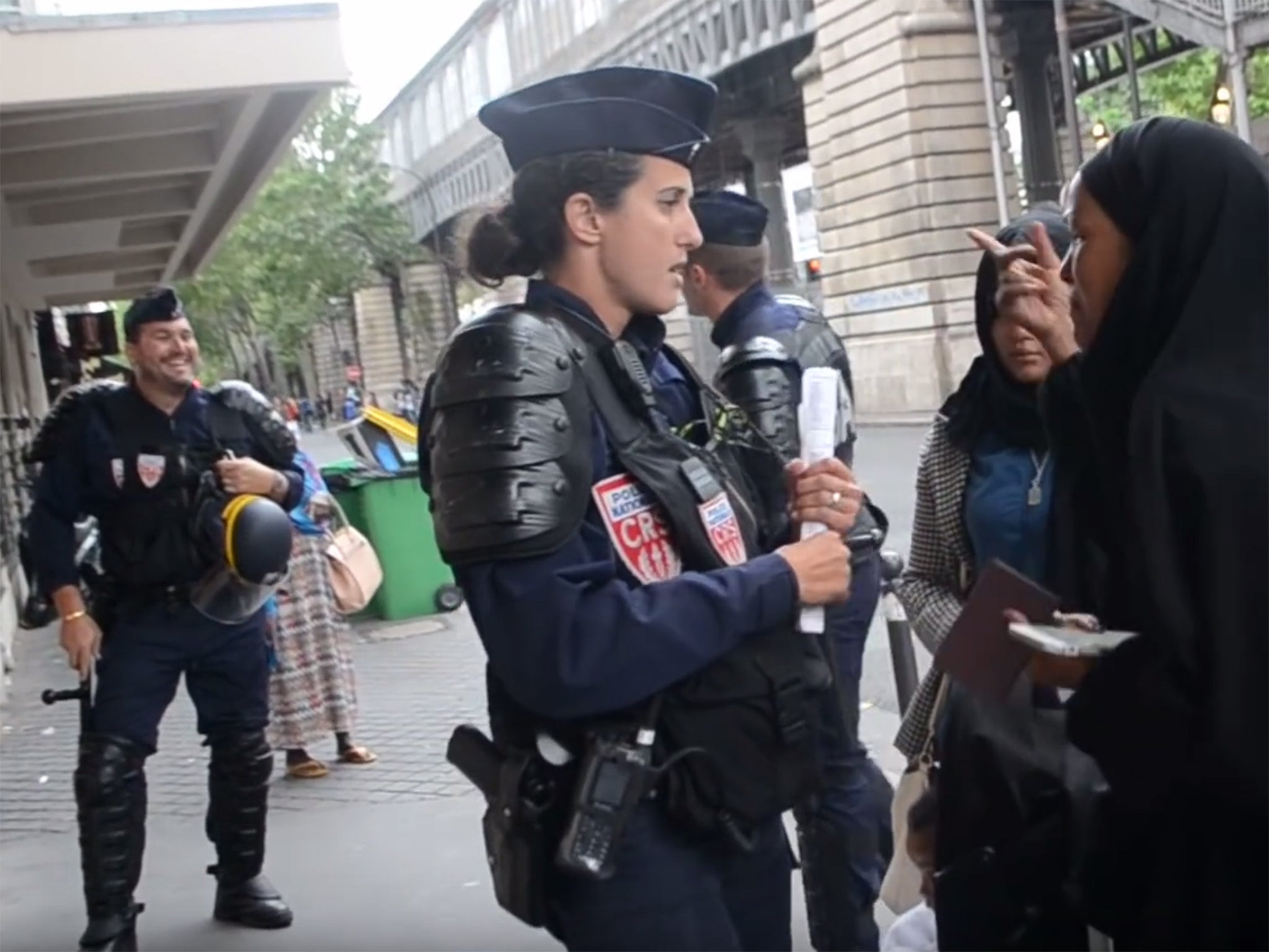 The officer appears to laugh as the woman cries