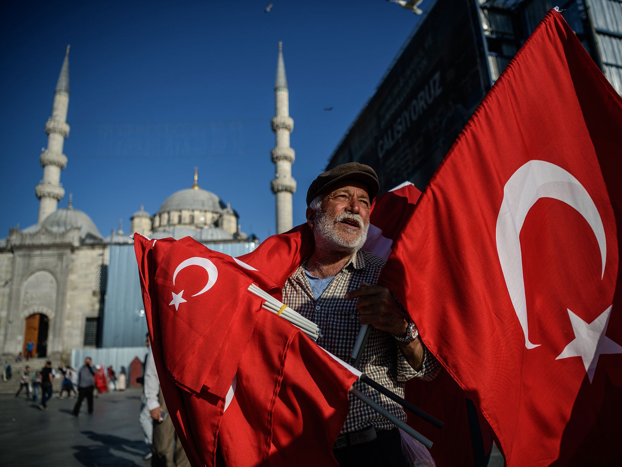 A man sells Turkish flags outside Istanbul's iconic Blue Mosque