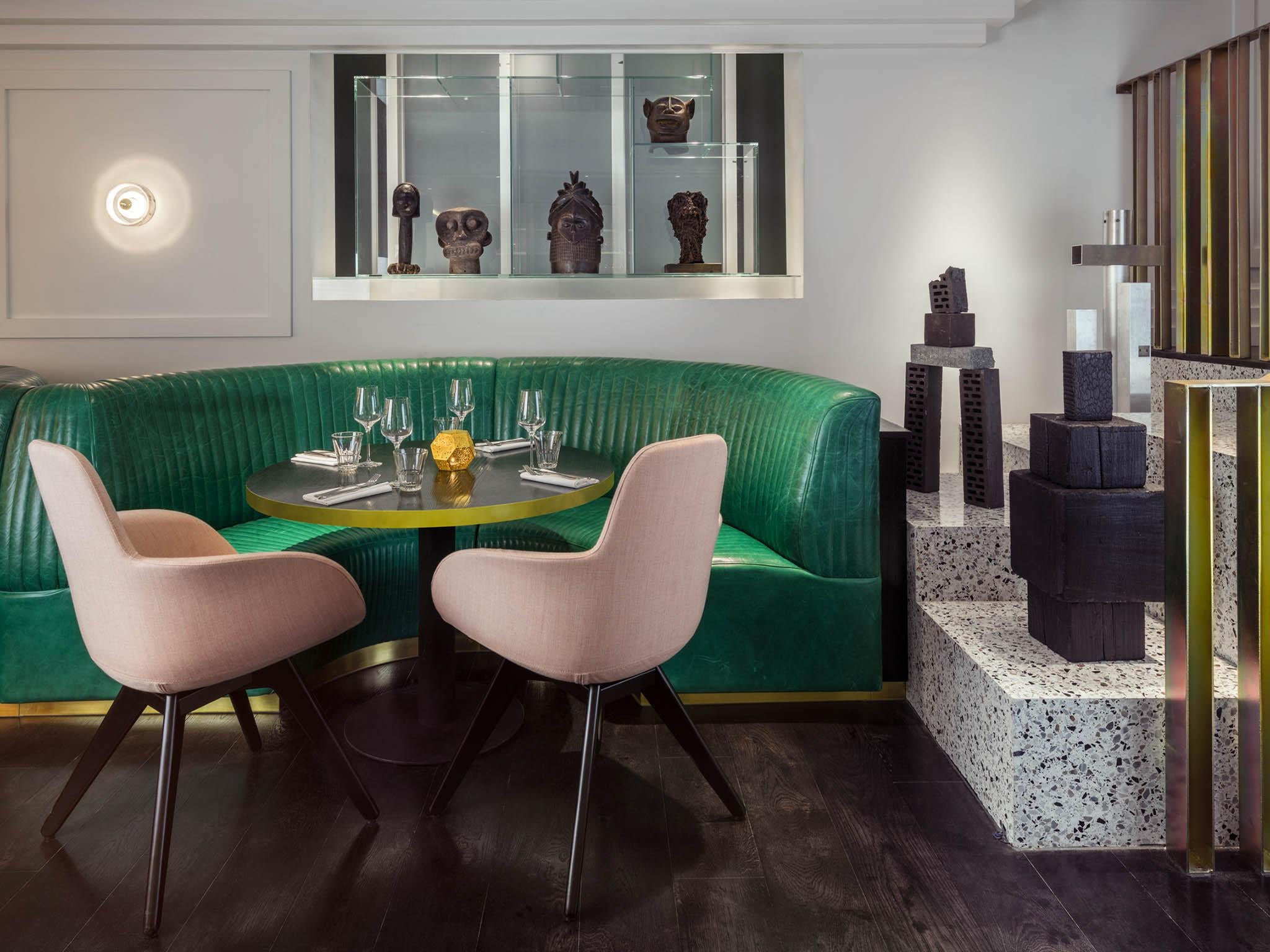 The interior of the dining room, with jade coloured booths and dusty pink seats