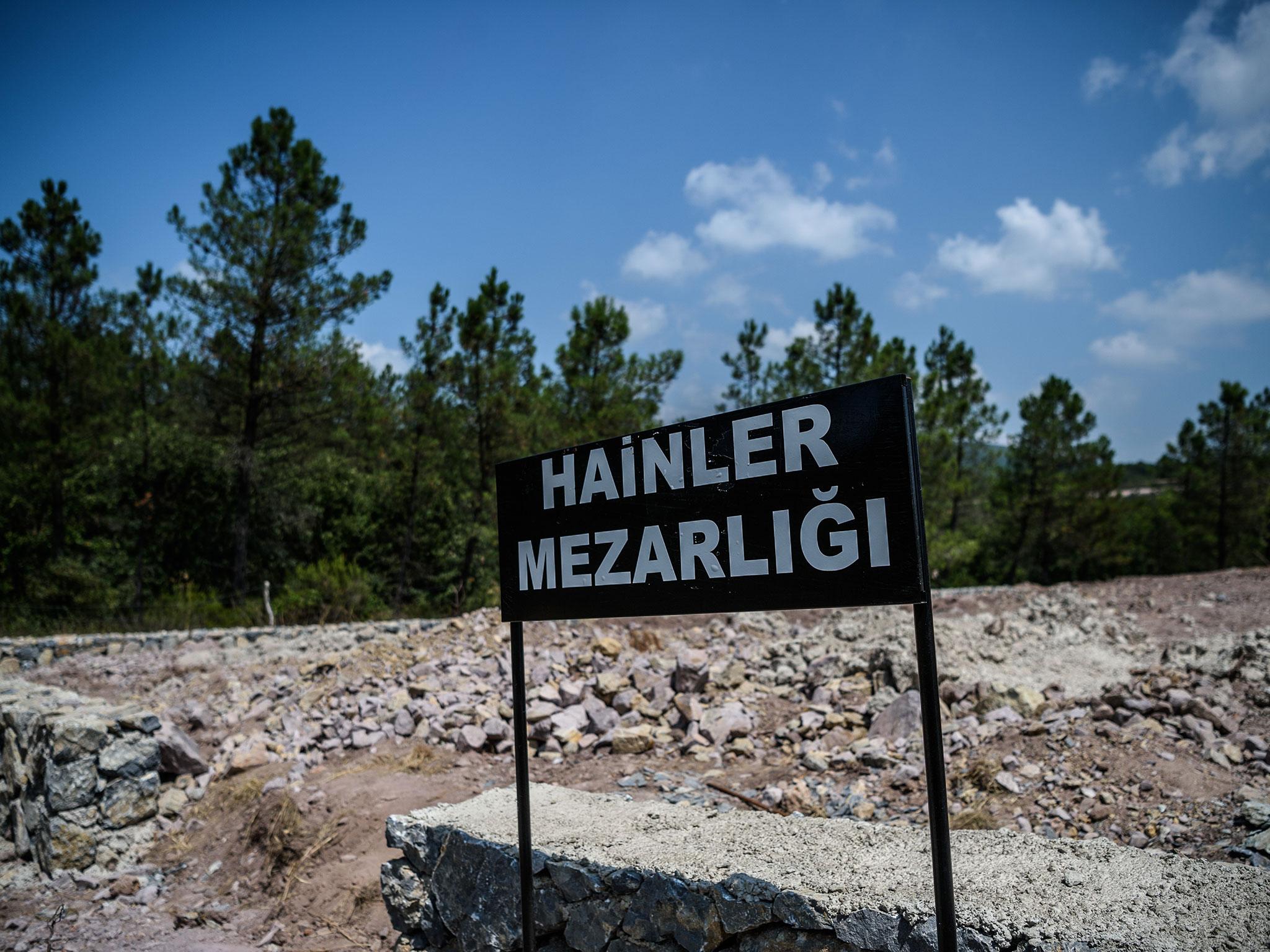 A sign reading 'Traitors' Cemetery' in Turkish is seen in front of unmarked graves built specially by the Istanbul municipality for those who died during the country's failed coup