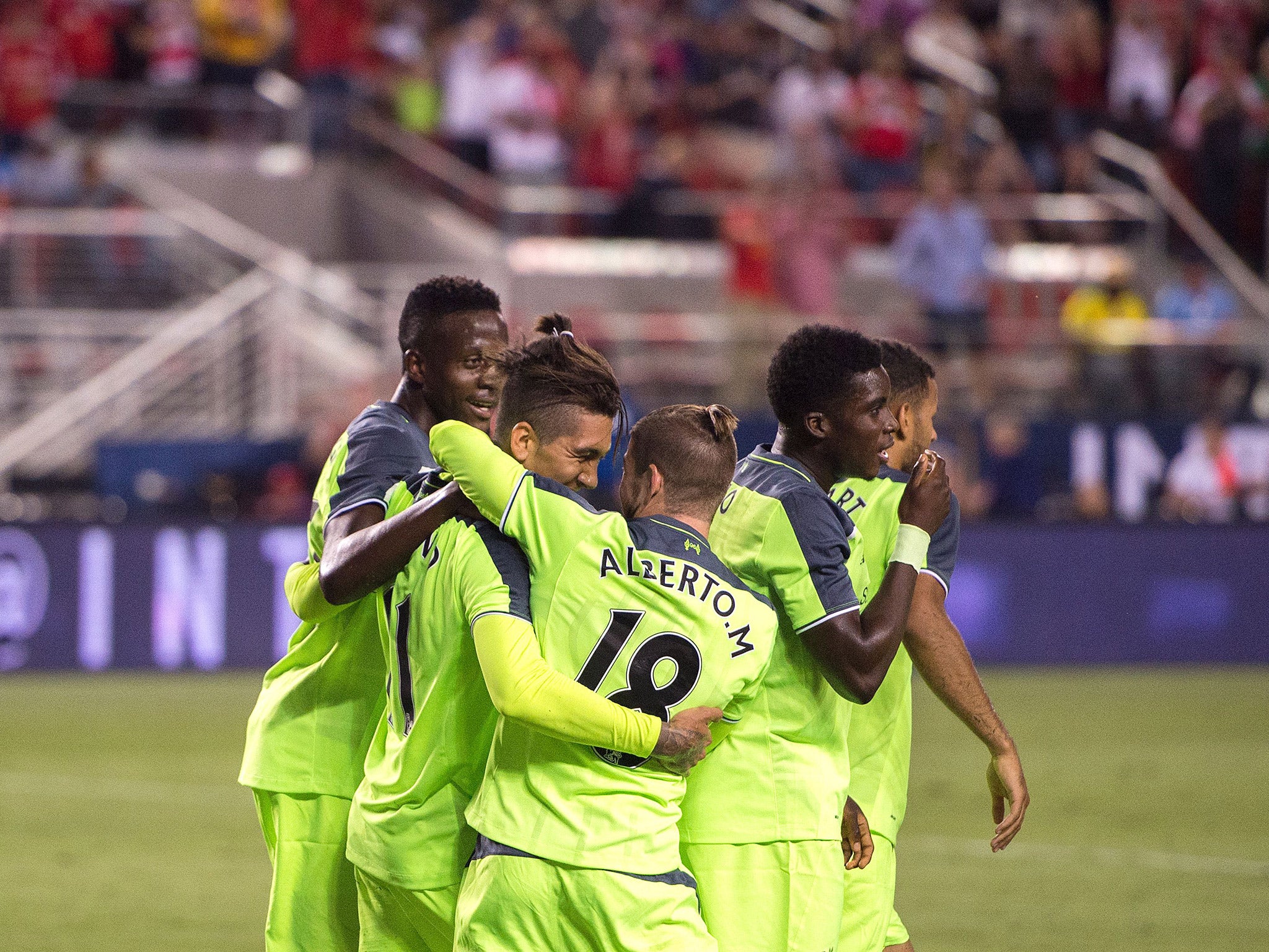 Liverpool players celebrate after Roberto Firmino puts them 2-0 ahead of AC Milan