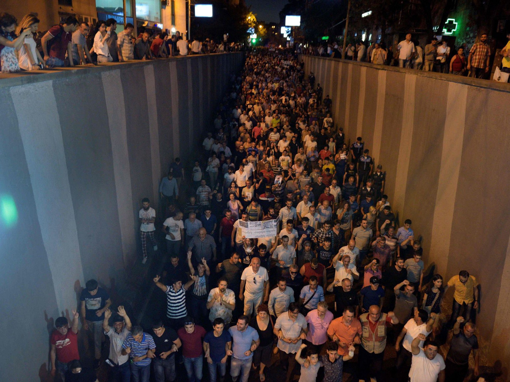 Opposition supporters march along the streets to the Erebuni police station seized by gunmen on Friday