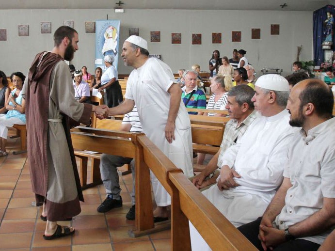 A catholic monk welcomes muslim worshippers in the Saint-Pierre-de-lAriane church