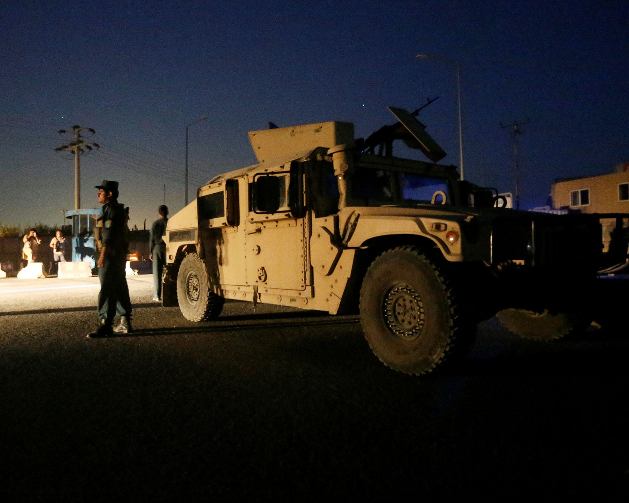 Aghan policemen keep watch near the site of a blast in Kabul