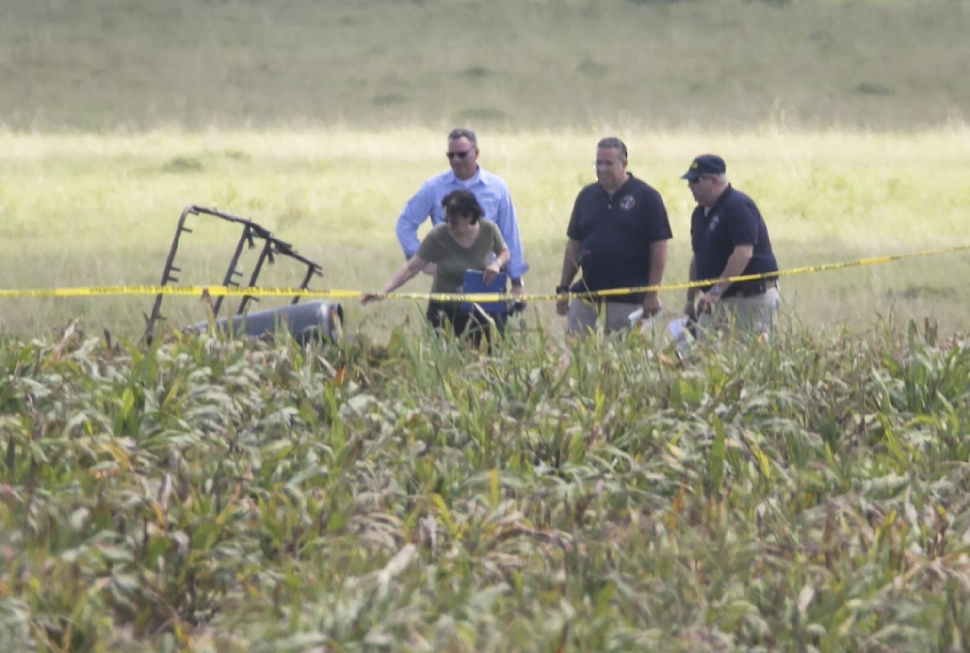 Investigators comb the wreckage of the crash in a field near Lockhart in Central Texas