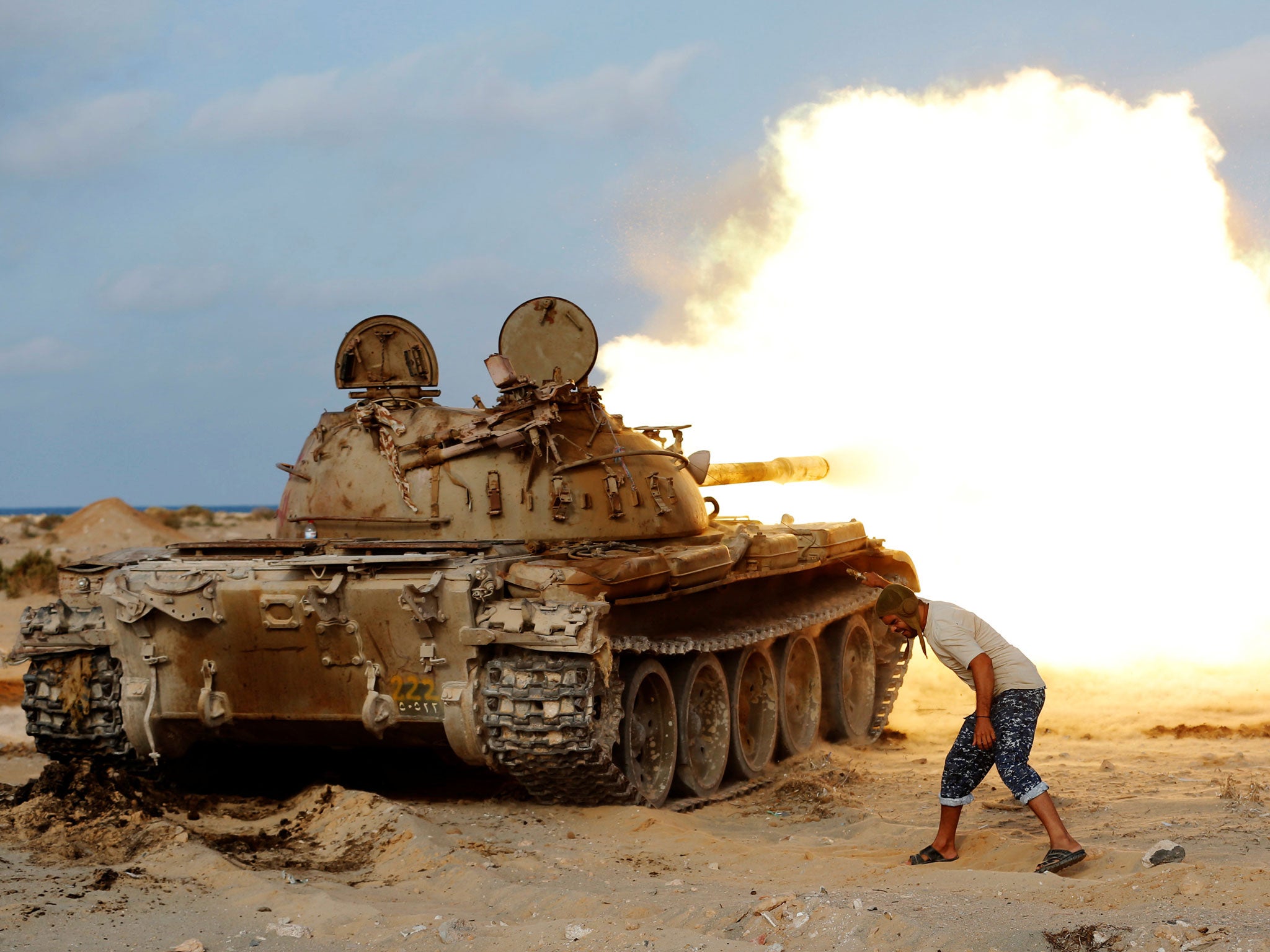 A fighter of Libyan forces allied with the UN-backed government fires a shell with Soviet made T-55 tank at Isis fighters in Sirte