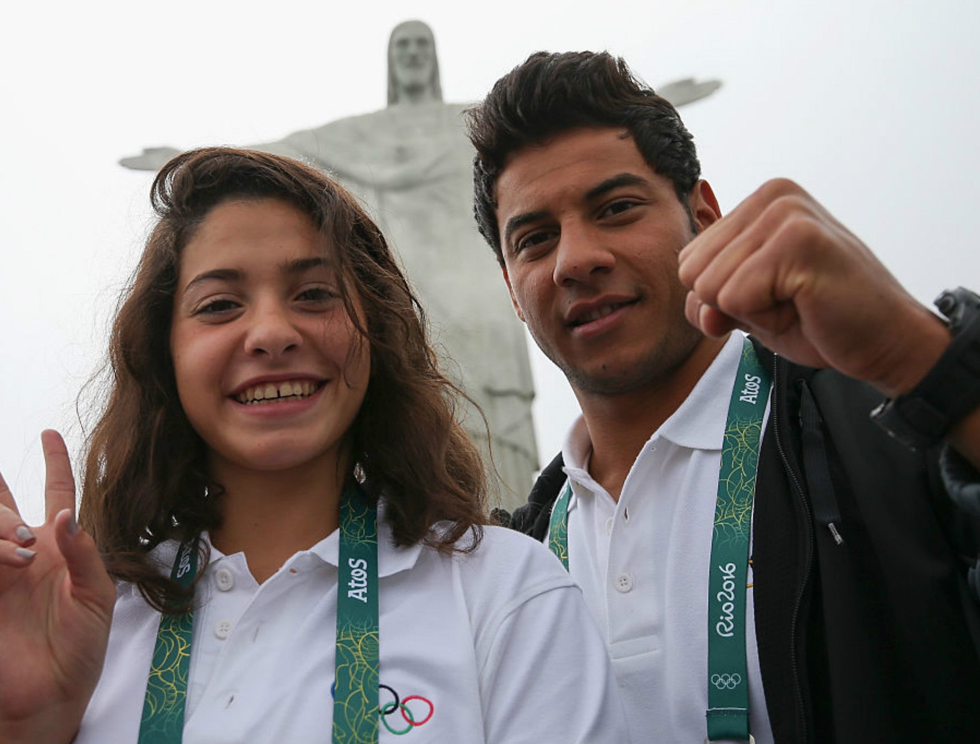 Olympic refugee team swimmers Yusra Mardini (L) and Rami Anis pose for a photo in front of the Christ the Redeemer statue on July 30, 2016 in Rio de Janeiro, Brazil.