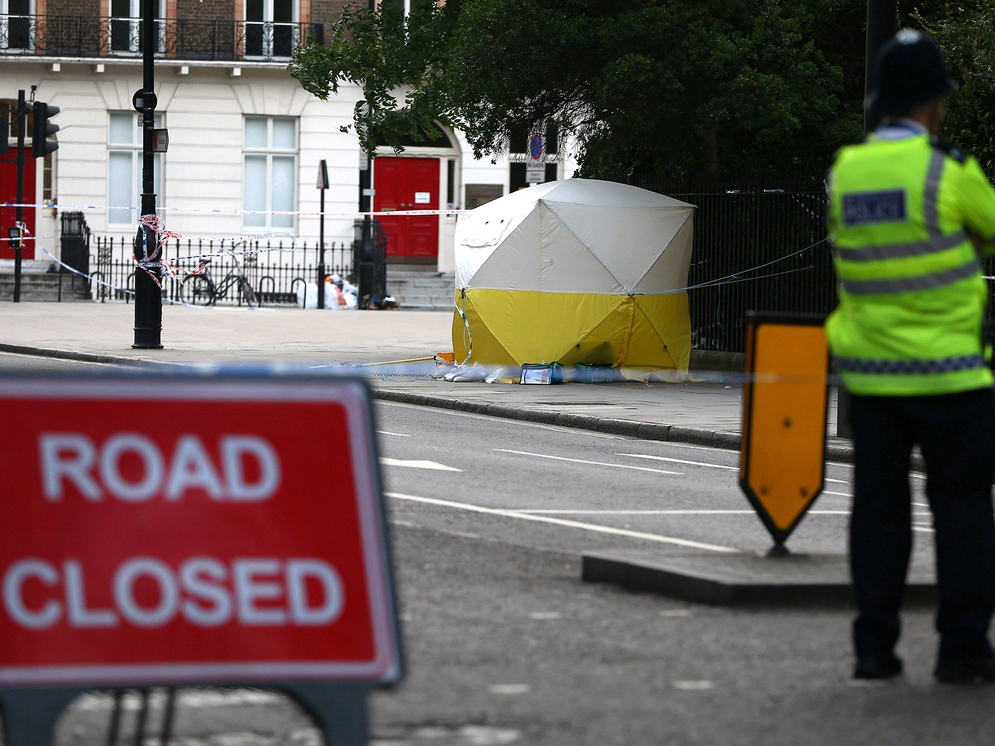 Police officers stand near a forensics tent after the knife attack in Russell Square