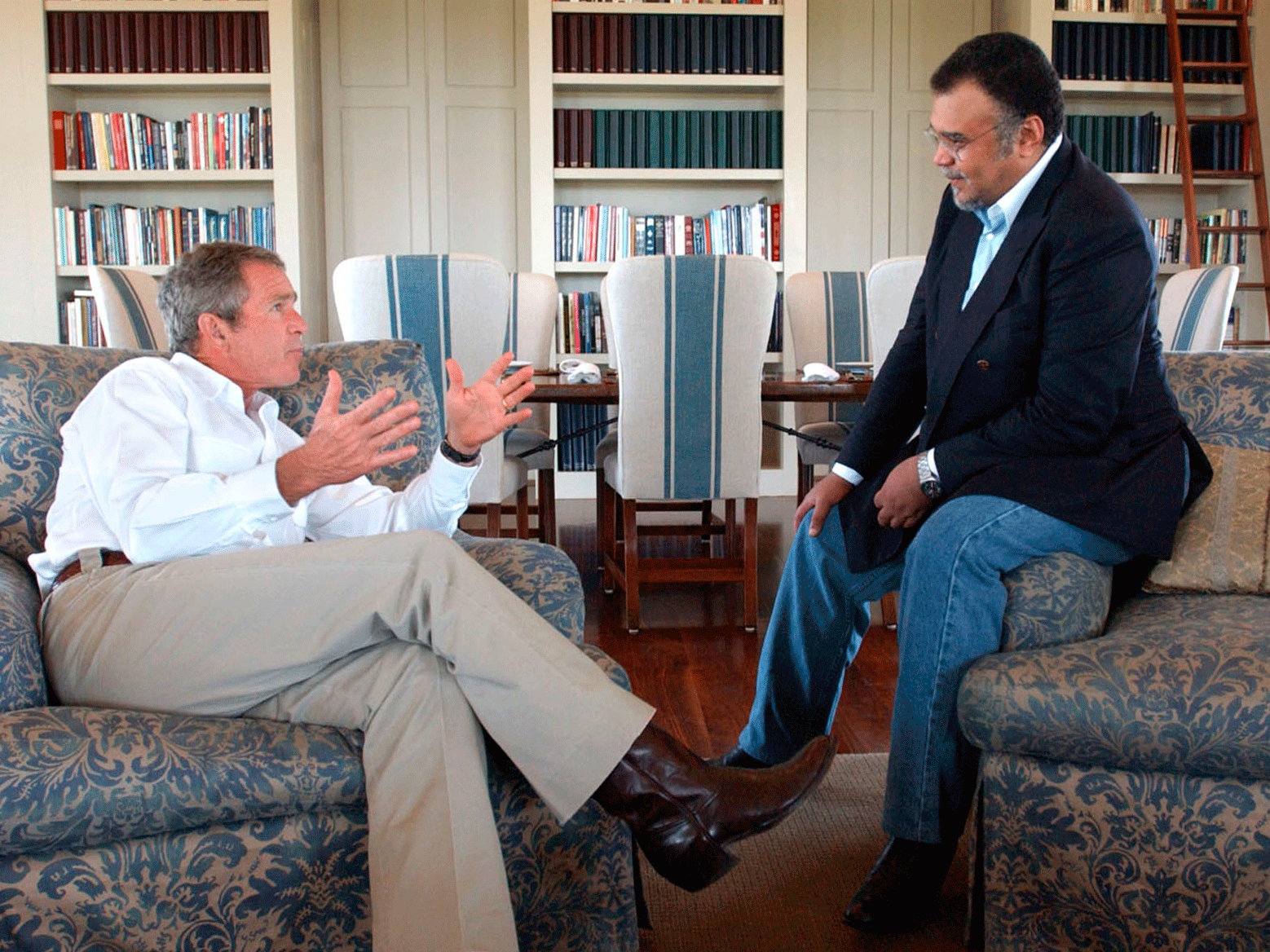 Prince Bandar bin Sultan, Saudi Ambassador to the US, speaking to former President George W Bush at the Bush Ranch in Crawford, Texas, in August 2002. An 'indirect link' between Prince Bandar and an al-Qaeda suspect is revealed in a 9/11 investigatory report