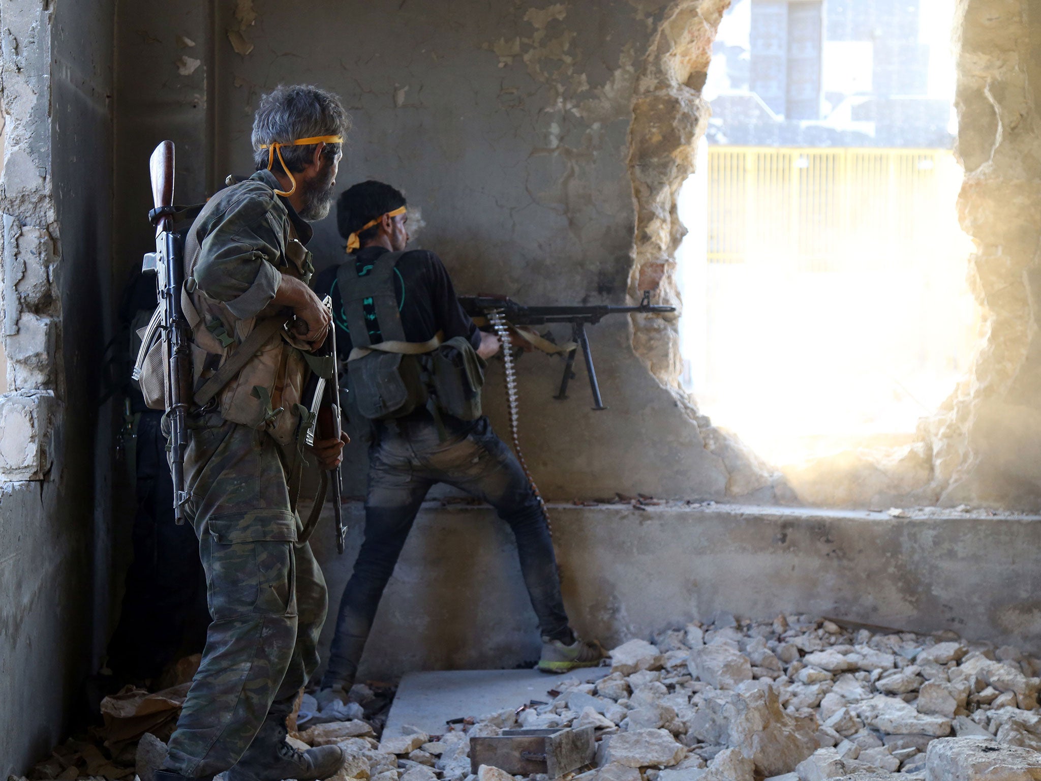 Rebel fighters fire towards regime forces positions on the outskirts of Aleppo