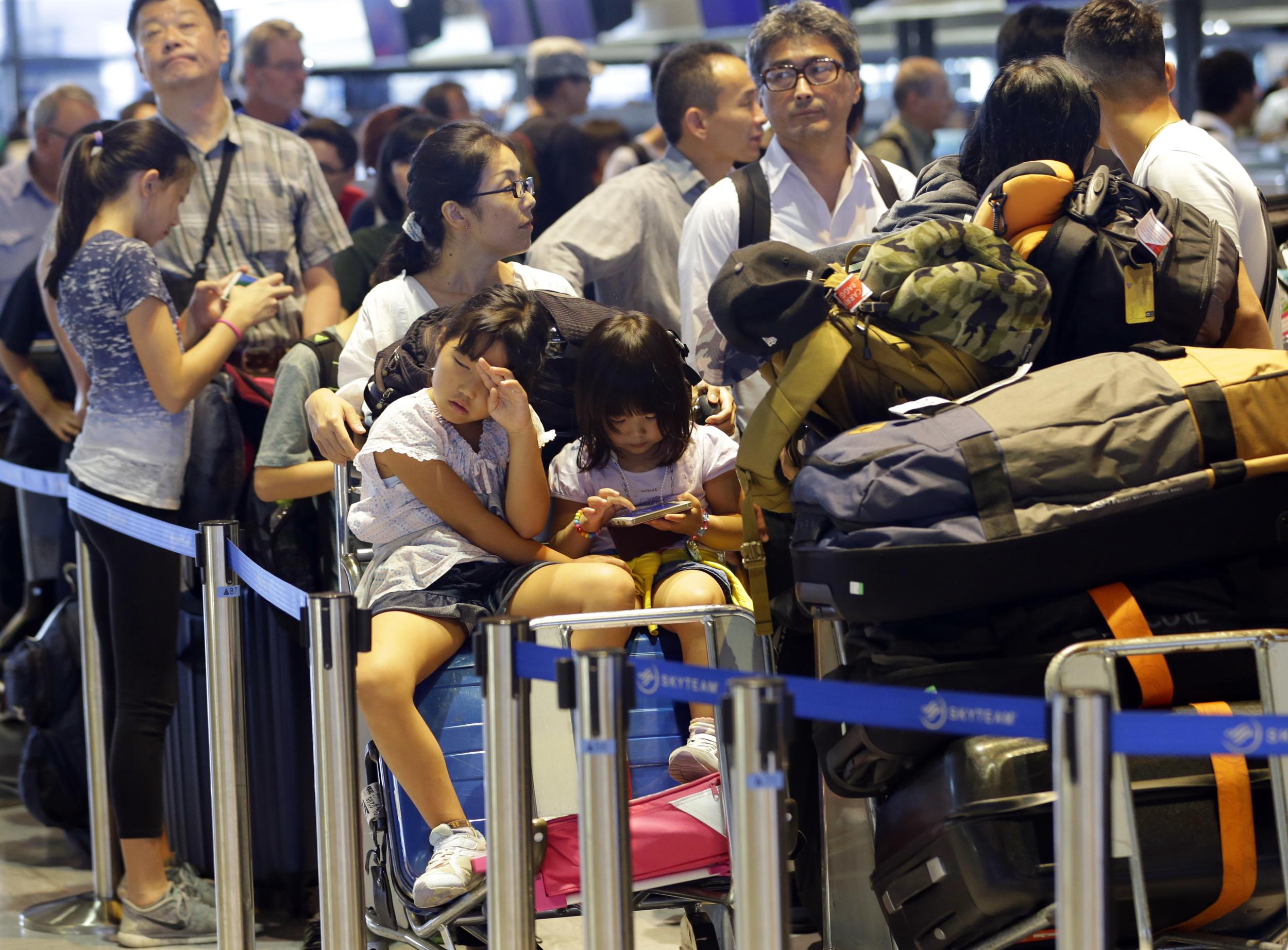 Passengers line up at a check-in counter for Delta Air Lines at Narita international airport in Narita, east of Tokyo, where more than 1,000 people were forced to spend the night.