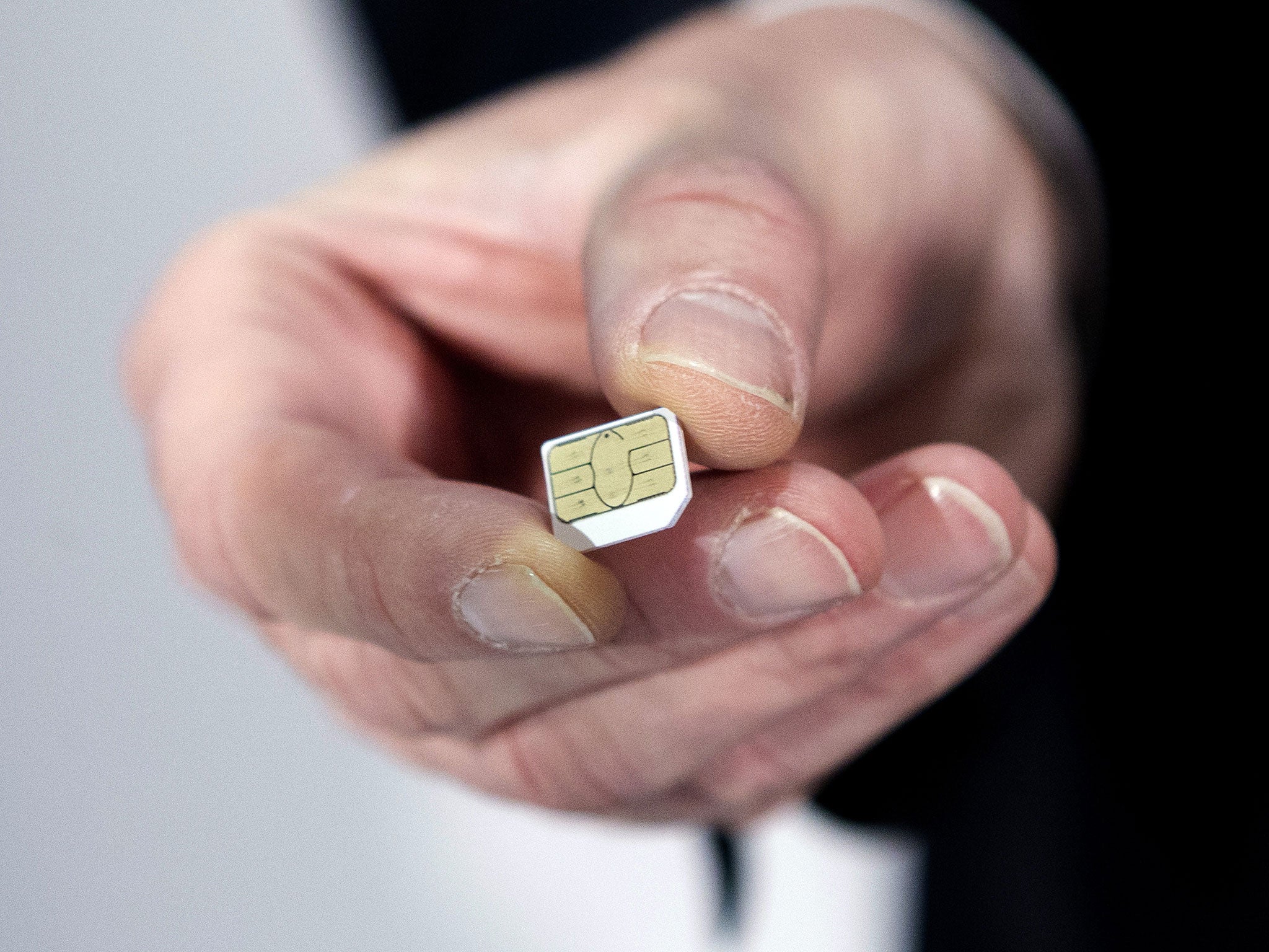 Gemalto CEO Olivier Piou shows a cell phone sim card before a press conference on February 25, 2015 in Paris.