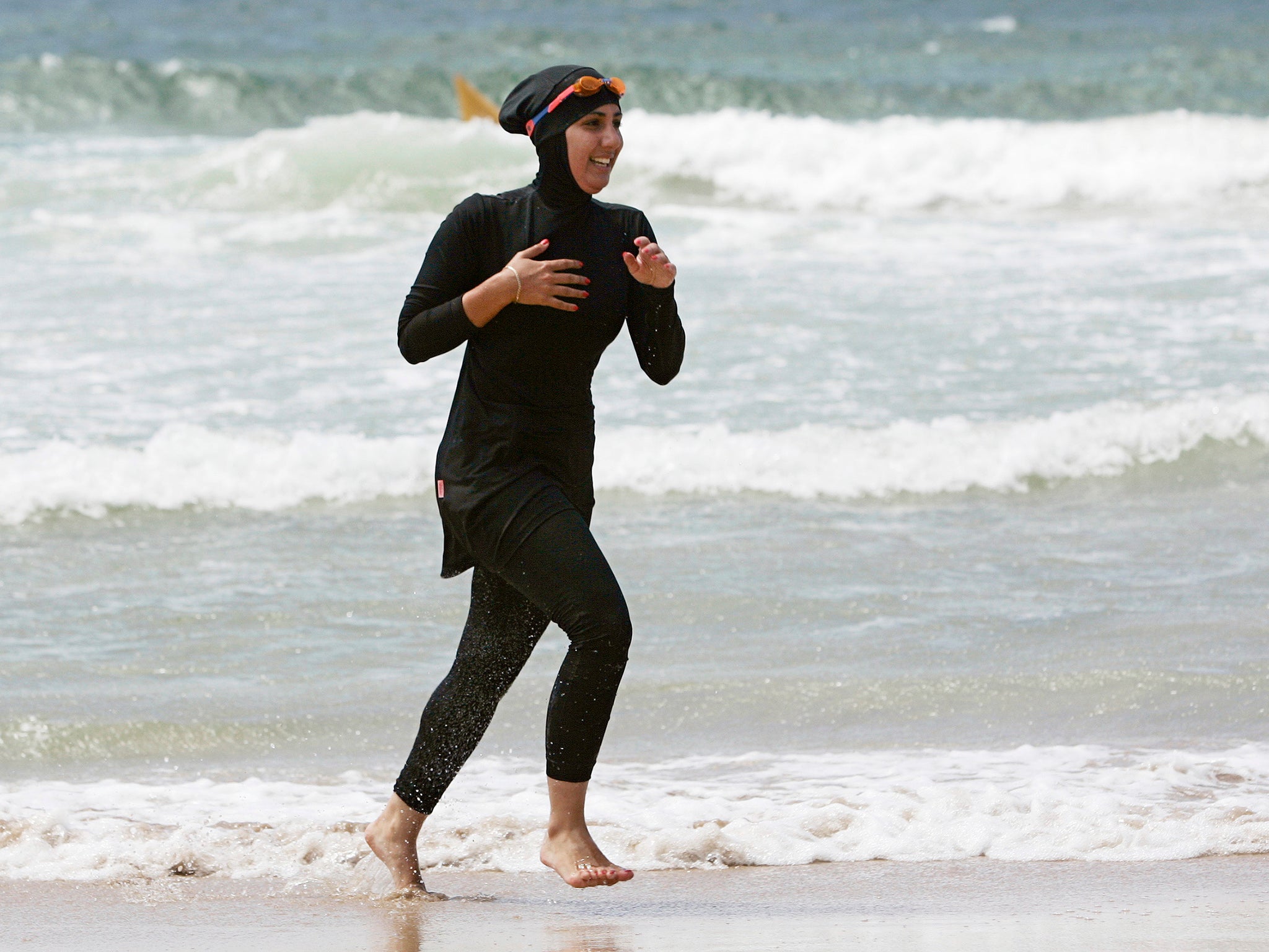 Volunteer surf life saver Mecca Laval runs along a beach in Sydney, 2007