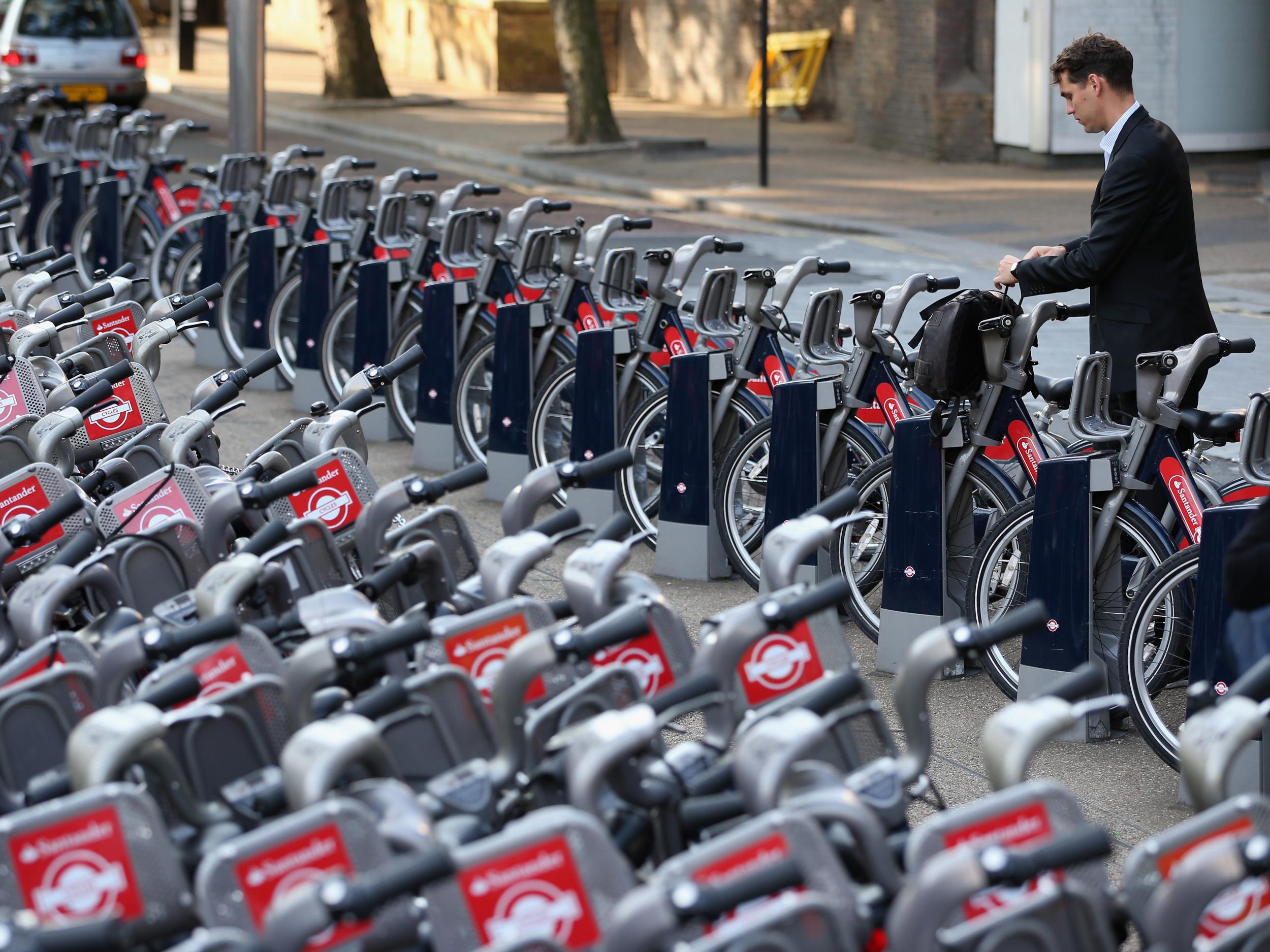 A commuter undocks a Santander Bike at Waterloo Station in London