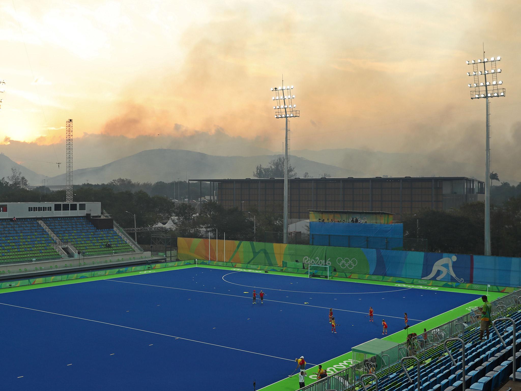 
Smoke rises from the forest fire behind the Deodoro hockey stadium 
