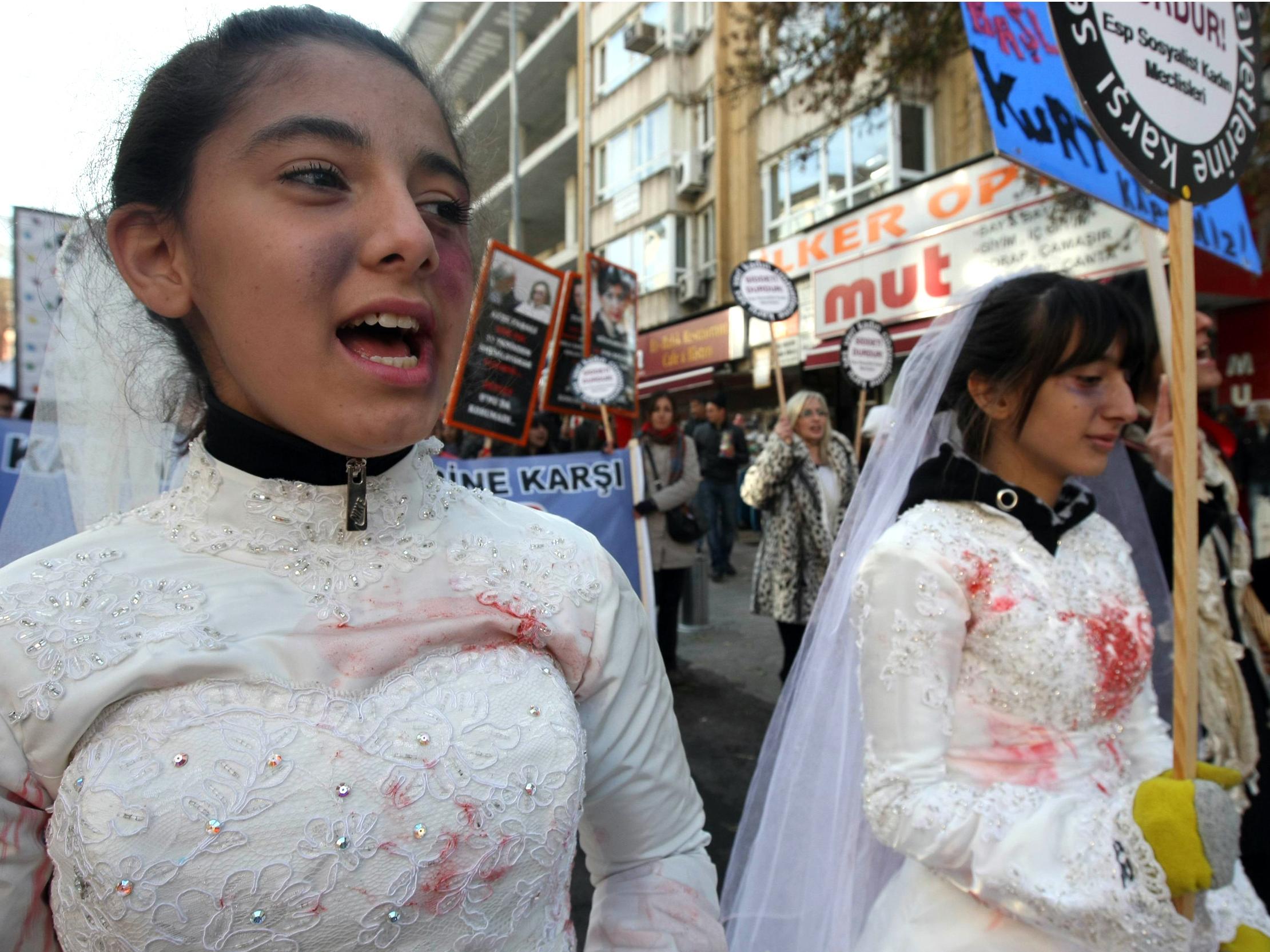 Turkish women, wearing wedding dressed and covered with fake bruises, at a protest against rape, killings and domestic violence against women