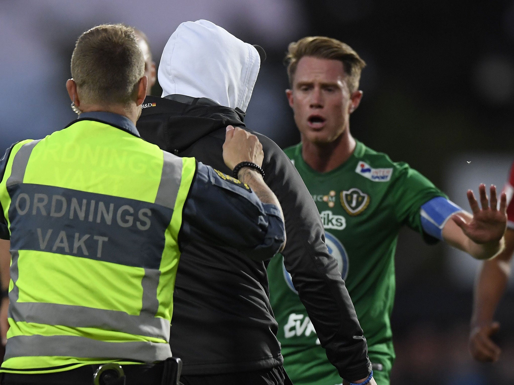 &#13;
The pitch invader is escorted away by security &#13;