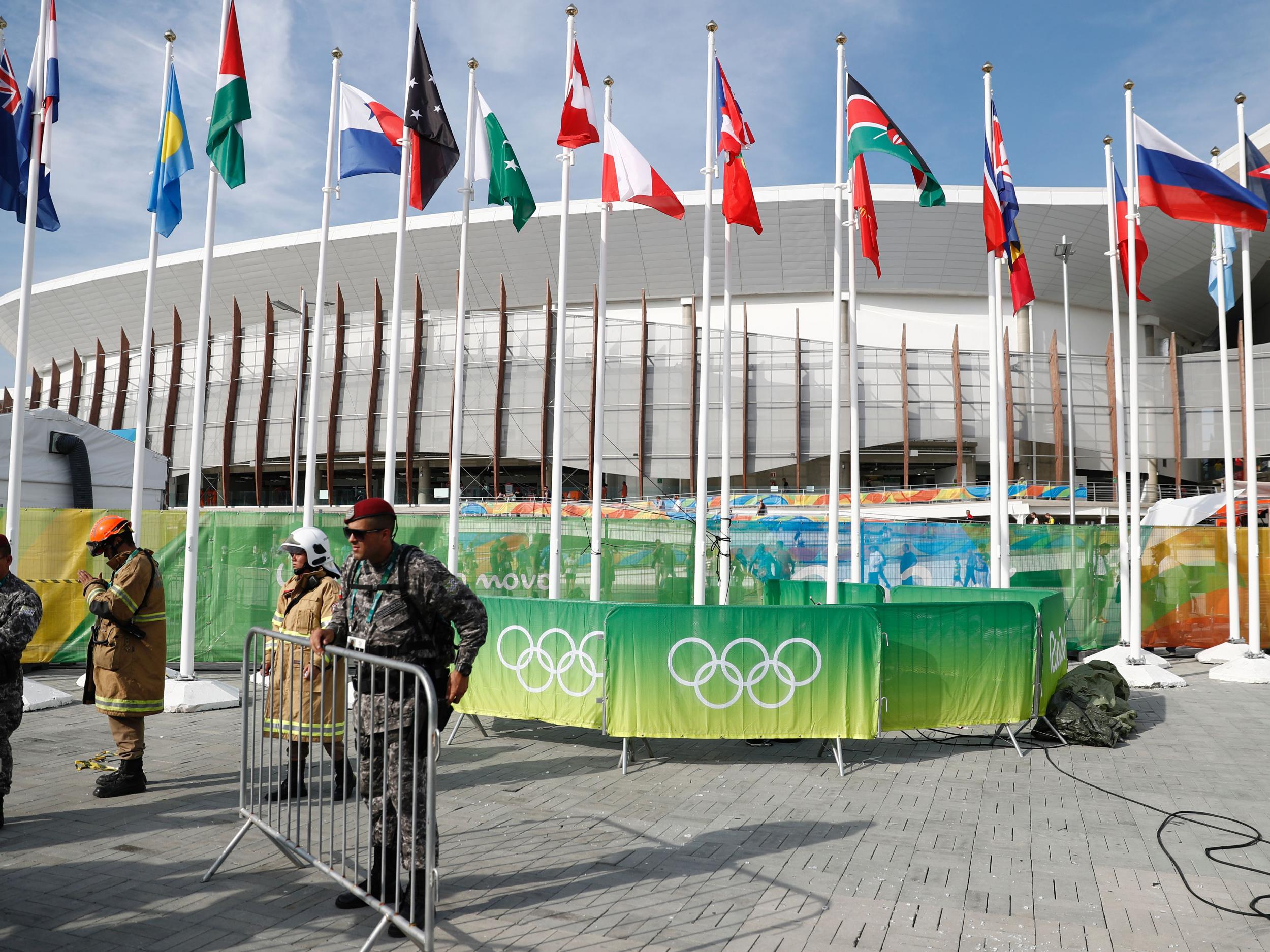 
Members of the military stand guard by a television camera that fell to the ground in the Olympic park 