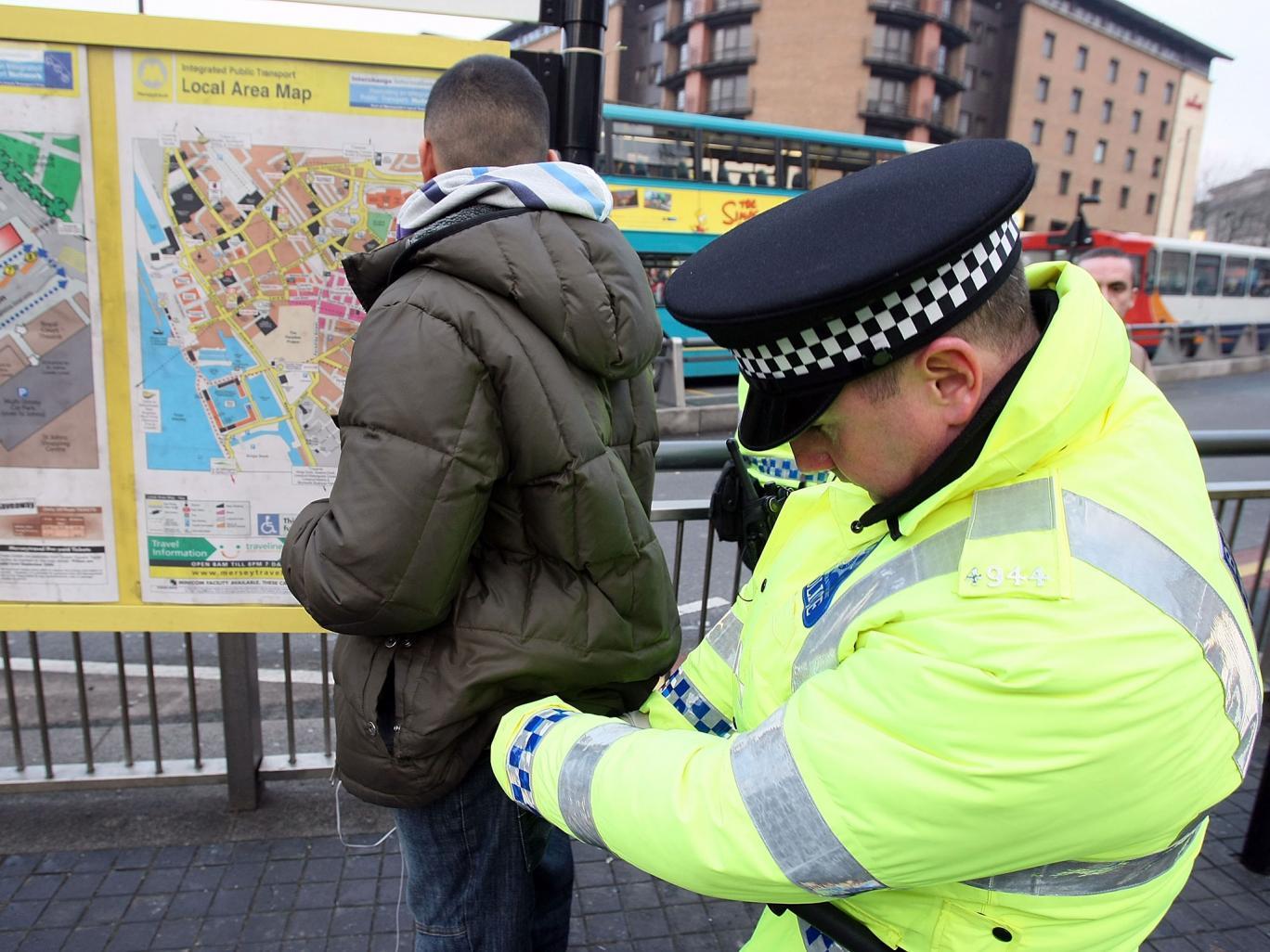 A police officer undertakes a 'stop and search' in Liverpool