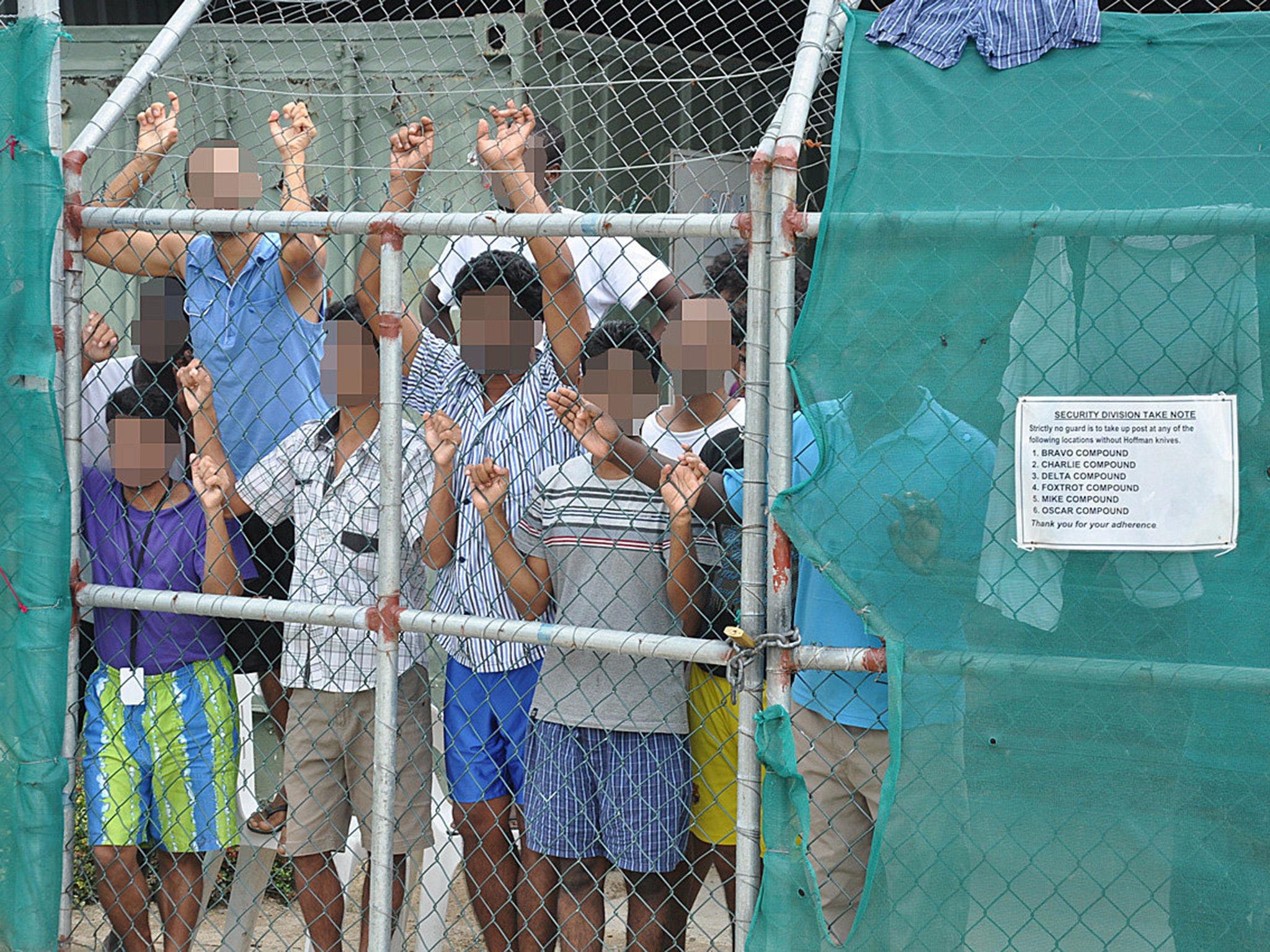 Asylum seekers behind a fence at the Manus Island centre in Papua New Guinea