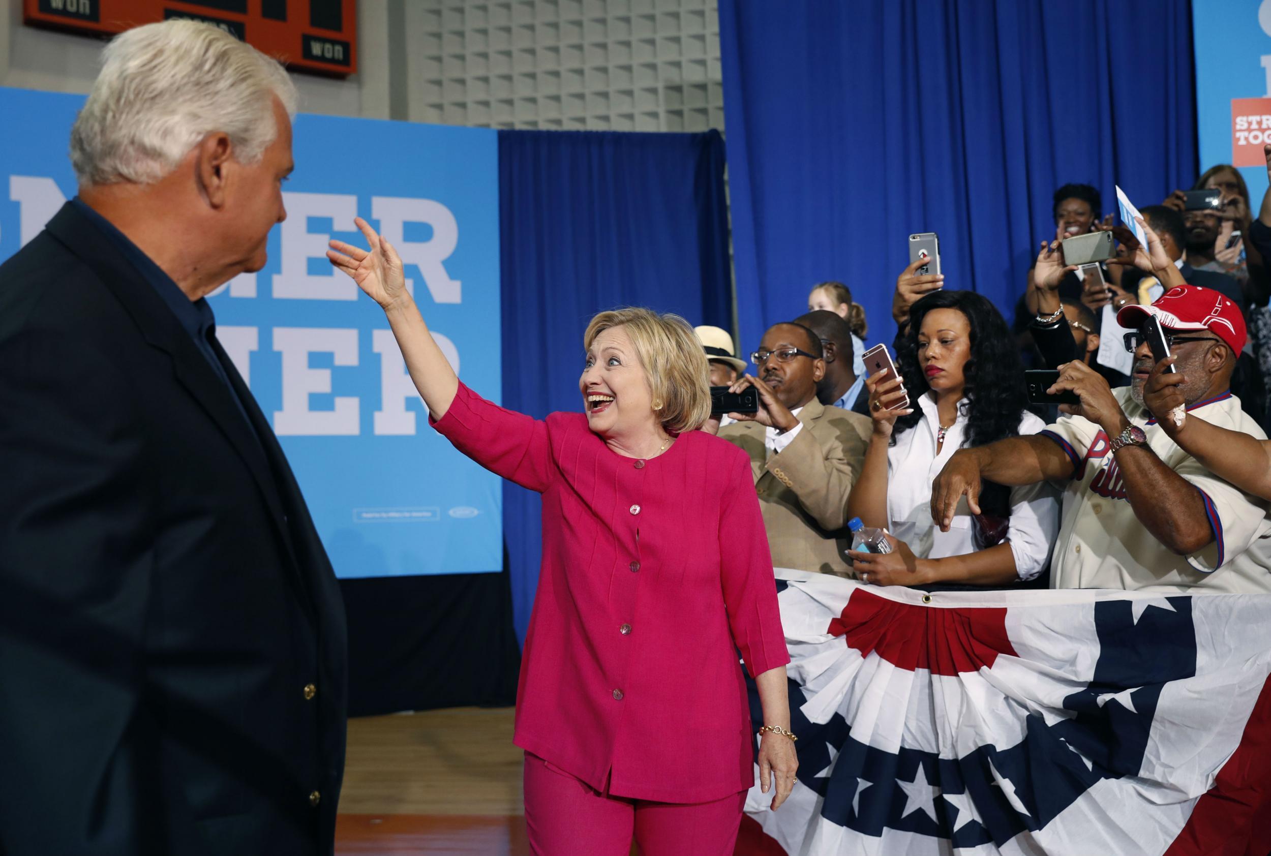 Ms Clinton waves to her supporters after a rally