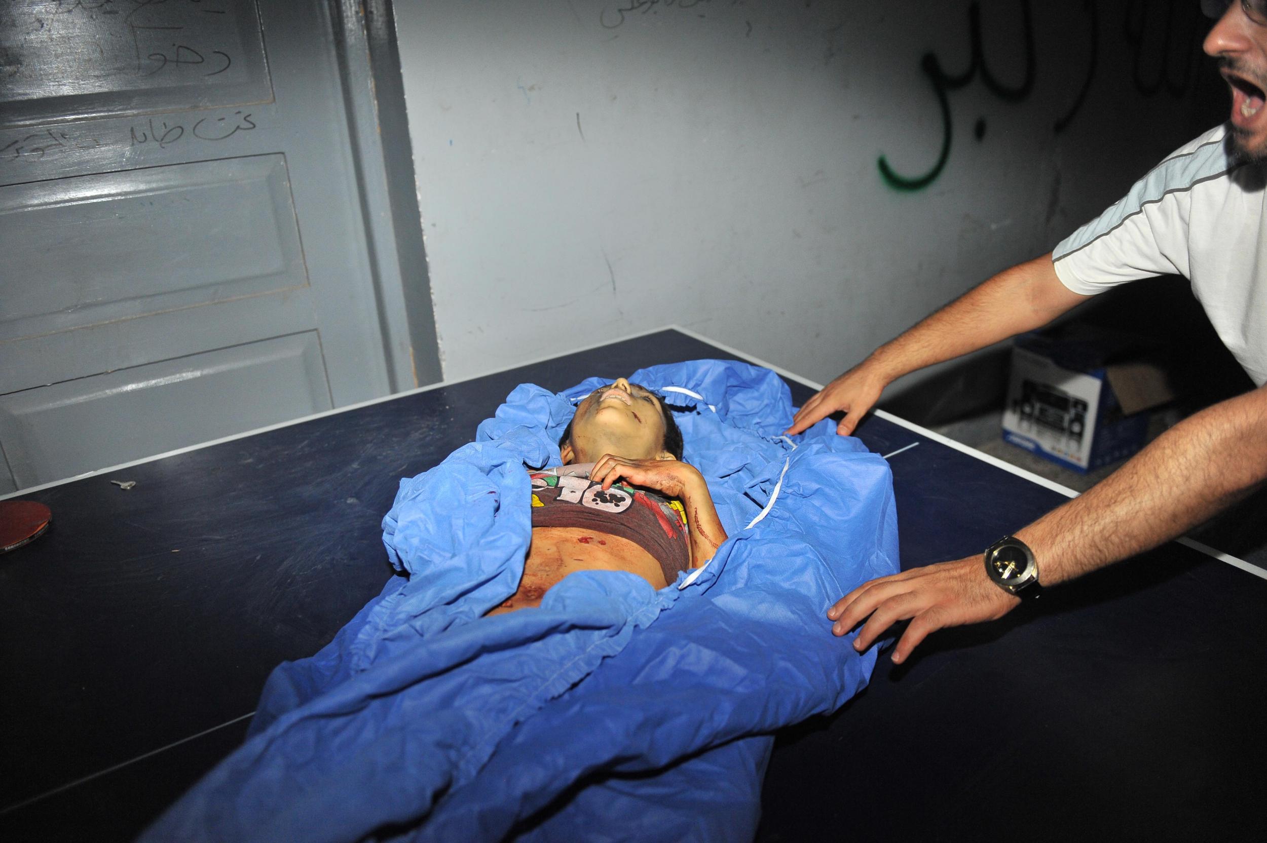 Photographer Bulent Kilic captured this image of a Syrian man next to the body of five-year-old Mohammed Amumrej killed during shelling by government forces in Aleppo on July 25, 2012