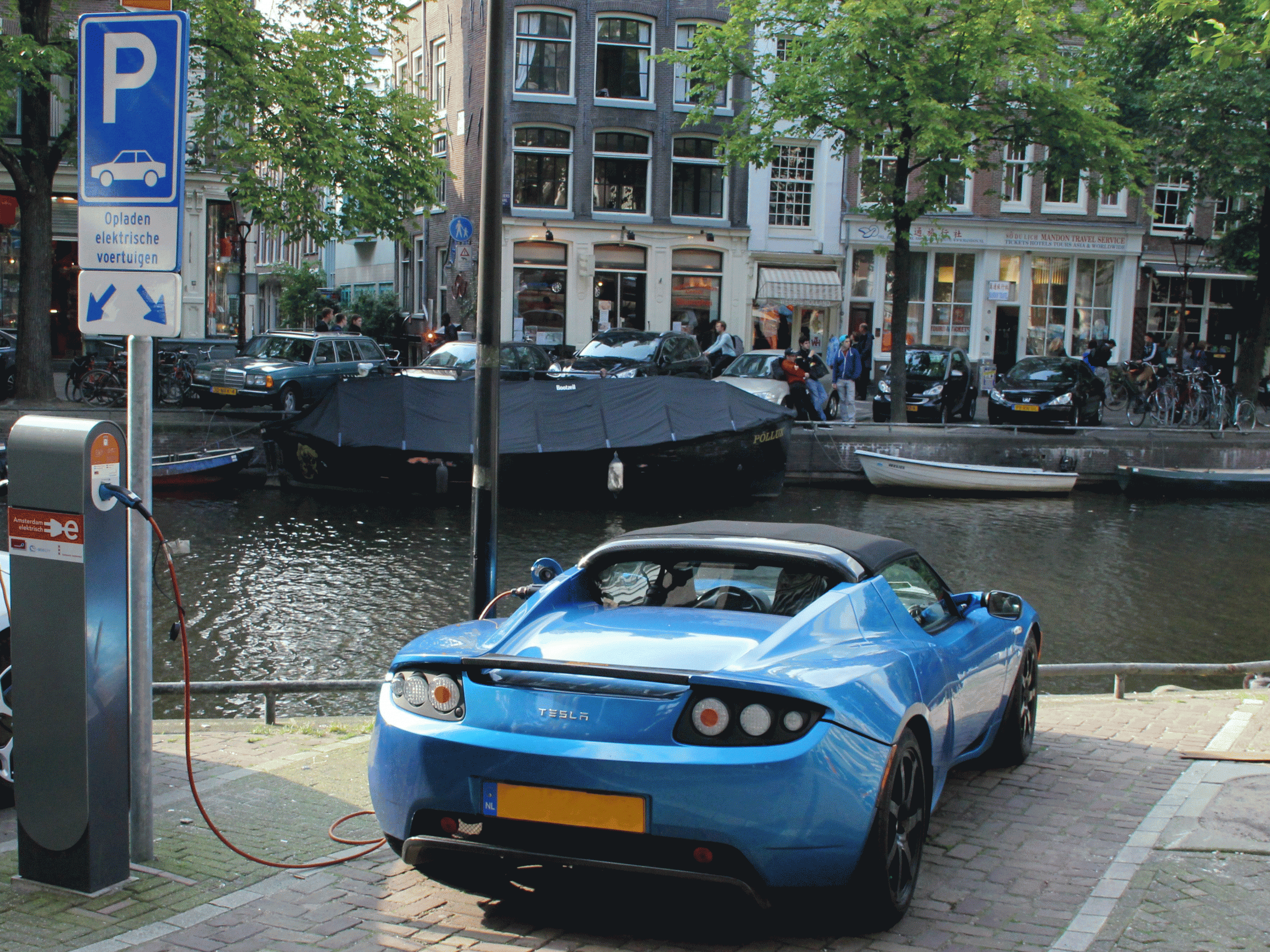 An electric Tesla car recharges on the banks of a canal in Amsterdam. Labour is considering a ban on the sale of new petrol cars in the UK