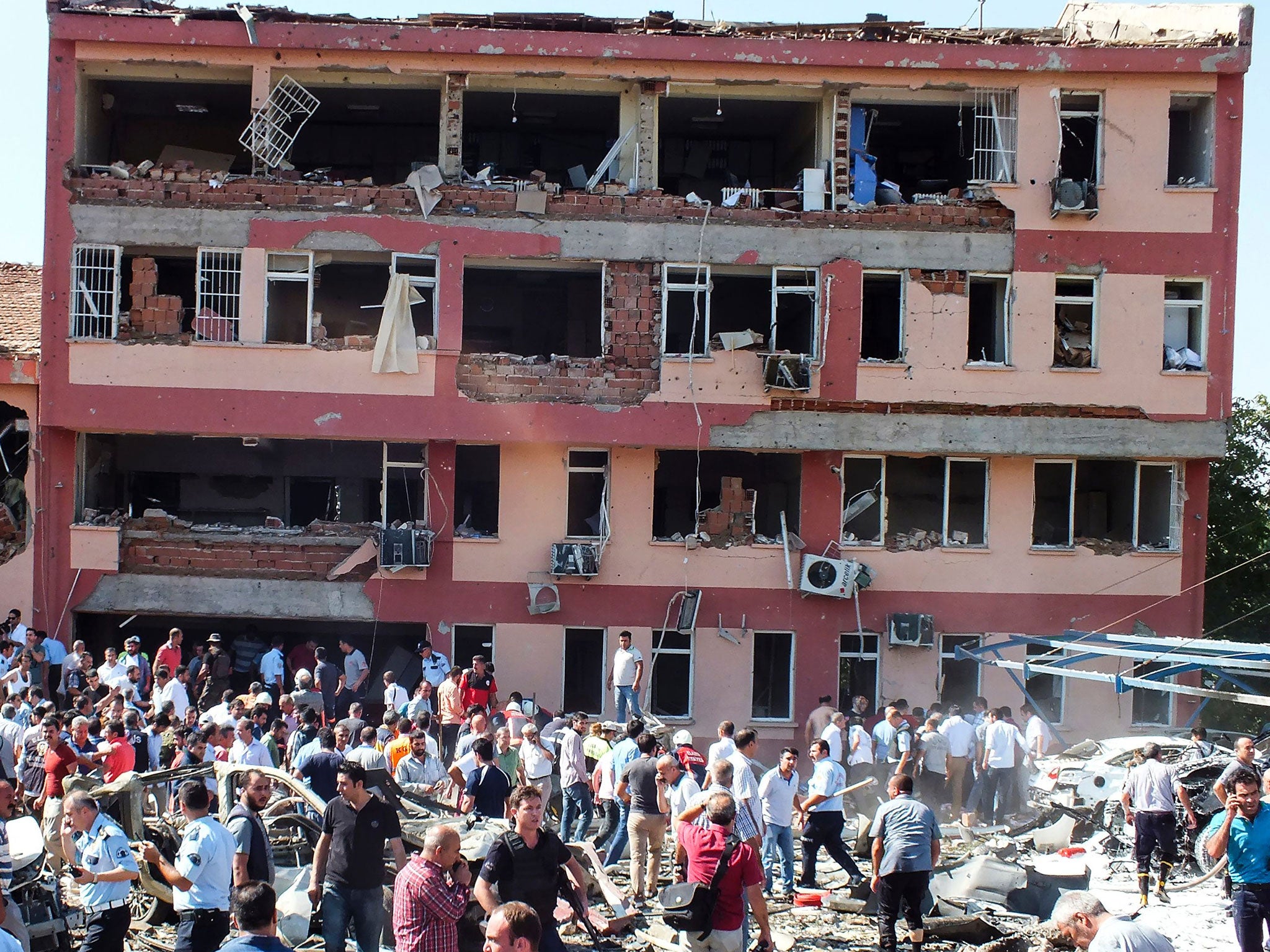 Members of the public and police inspect the site of a car bomb attack on a police station in the eastern Turkish city of Elazig on August 18, 2016.