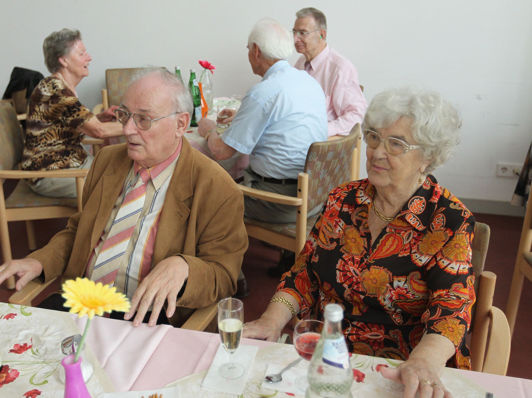 Elderly people chat at tables and watch others dance during an afternoon get-together in the community room of the Sewanstrasse senior care home in Lichtenberg, Berlin