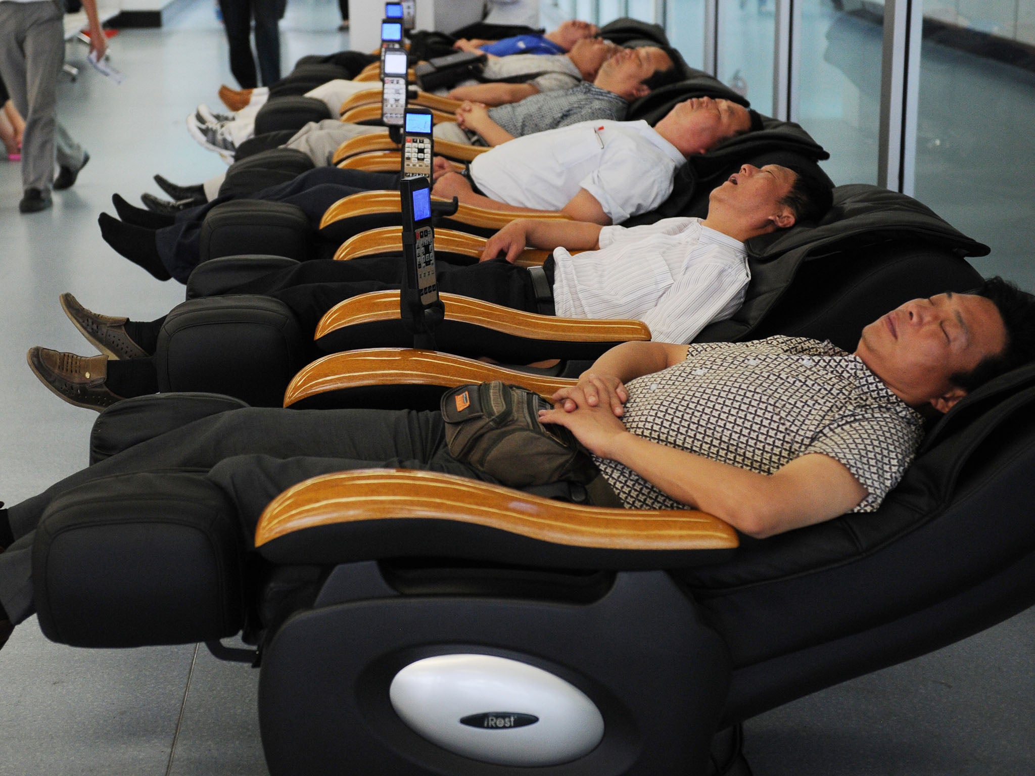 Passengers sleep in massage chairs in Yichang Sanxia airport in central China