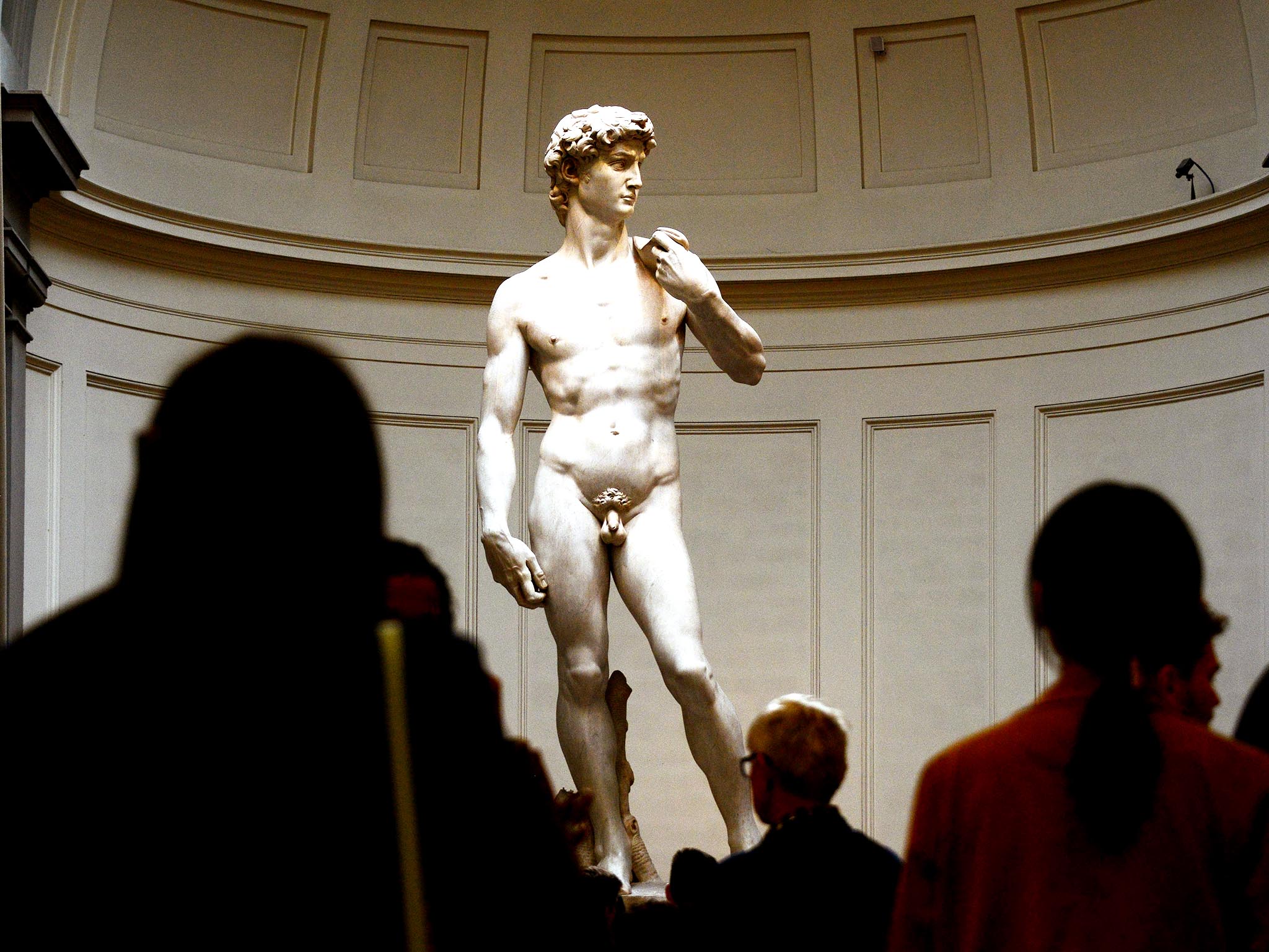 People look at the original 16th century statue of David by Italian artist Michelangelo Buonarroti in the Galleria dell'Accademia on April 9, 2015 in Florence