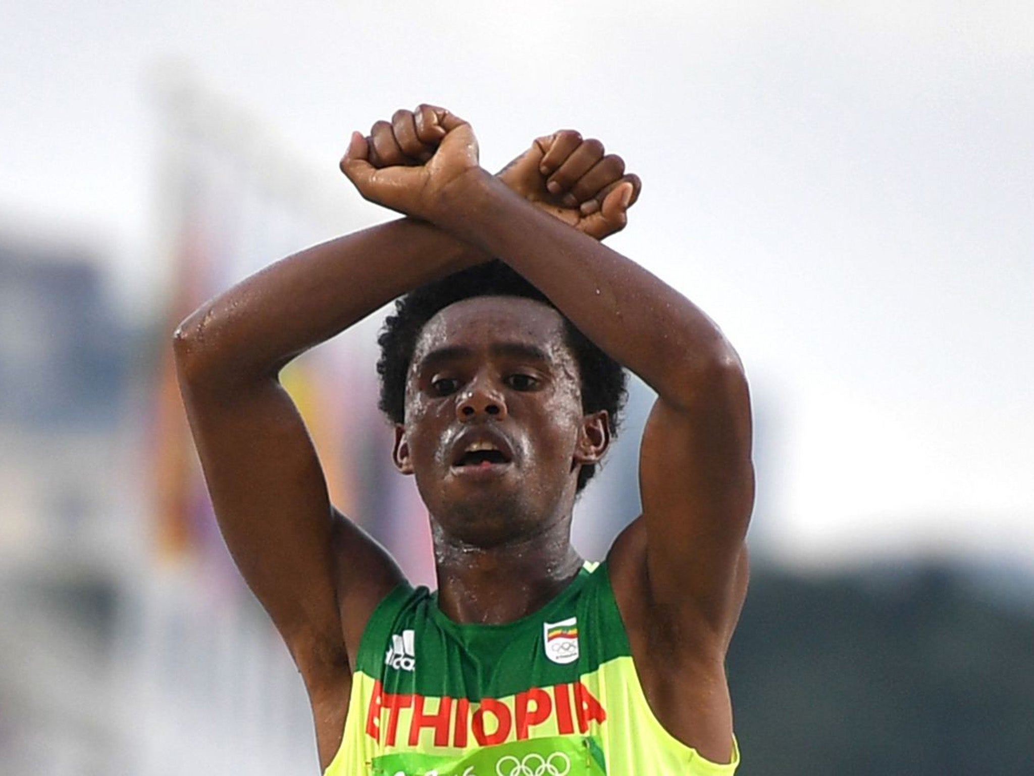 Feyisa Lilesa holding up his arms above his head in an X as a tribute to the Oromo people