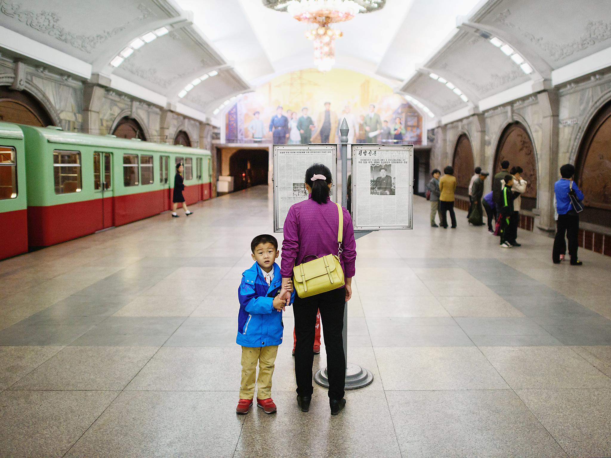 A woman and child stand in a Pyongyang subway station on October 12, 2015. . / AFP / ED JONES (Photo credit should read ED JONES/AFP/Getty Images)