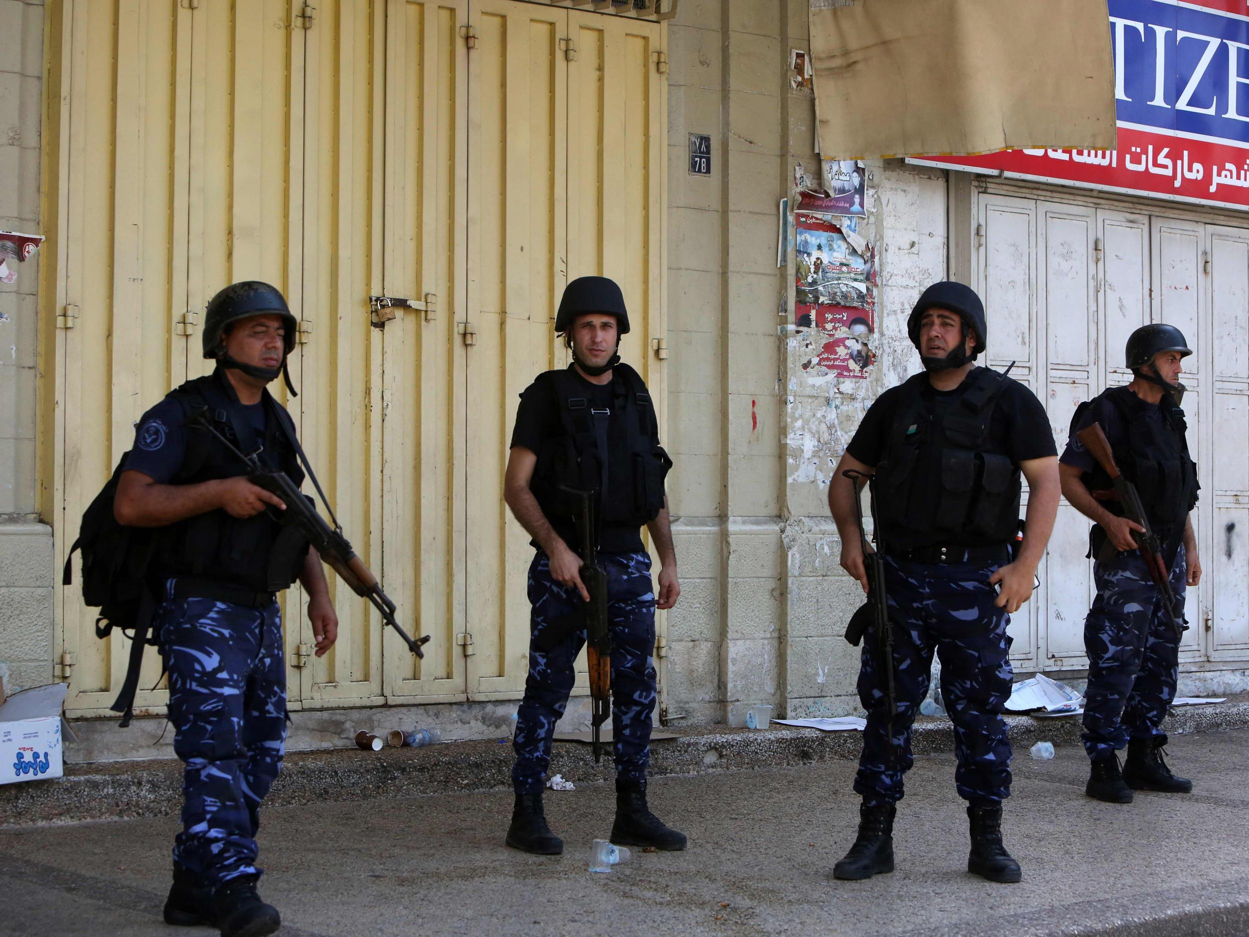 Members of the Palestinian security forces stand guard as they patrol the West Bank city of Nablus on August 23, 2016 during ongoing clashes between Palestinian gunmen and security forces