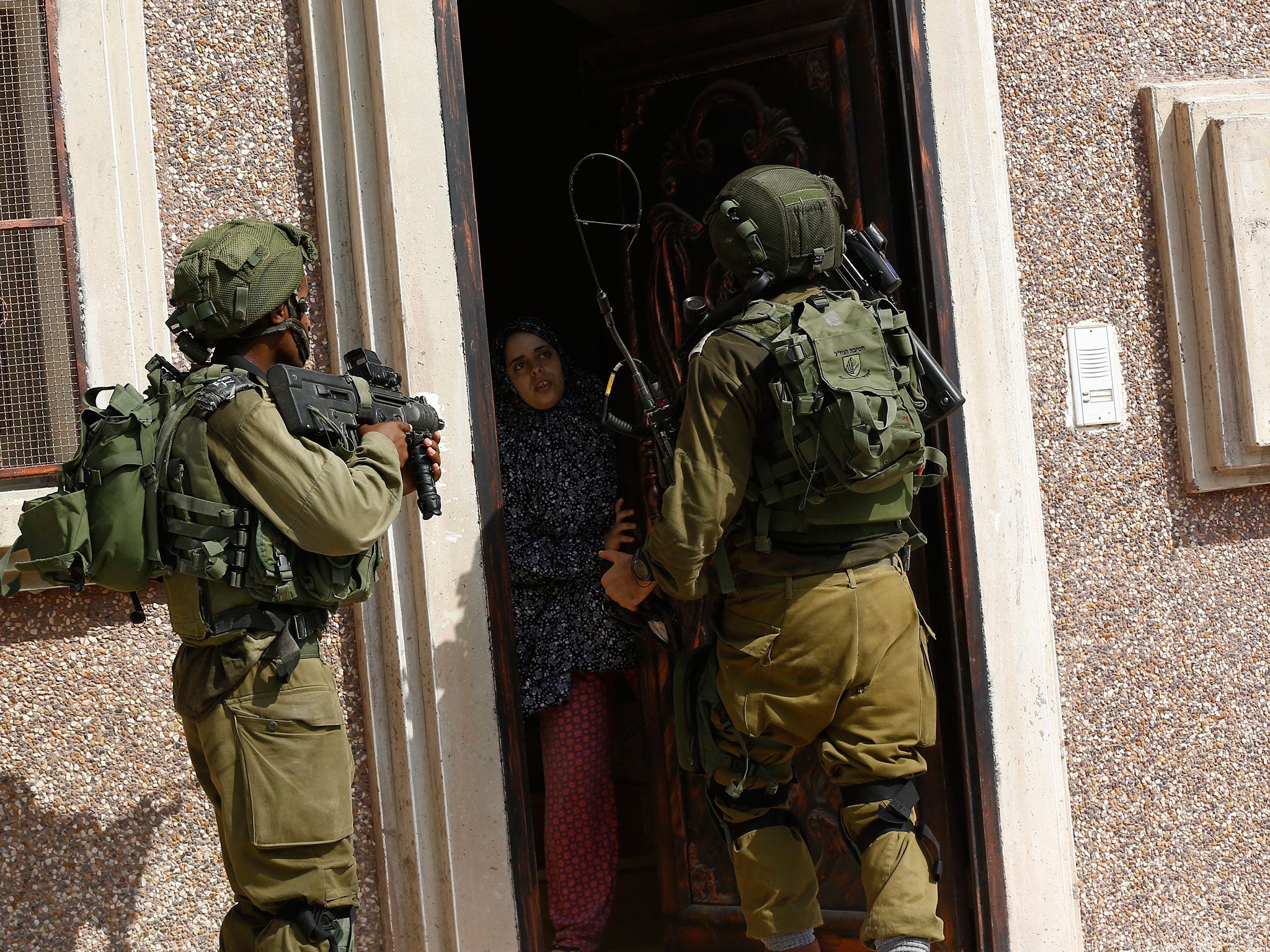 Israeli soldiers search a house in the West Bank village of Madama after an attack on 24 August 2016