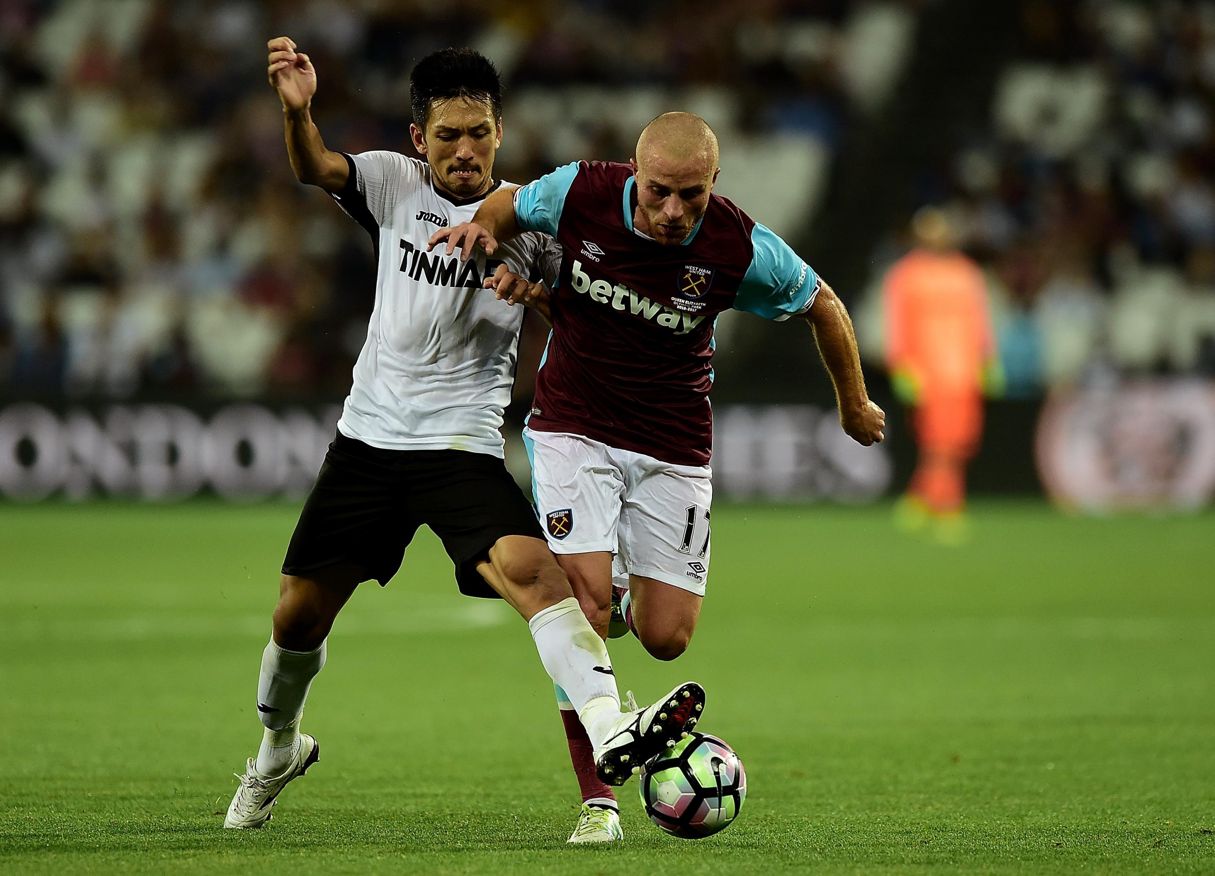 Gokhan Tore of West Ham holds off pressure from Takayuki Seto of FC Astra Giurgiu during the UEFA Europa League