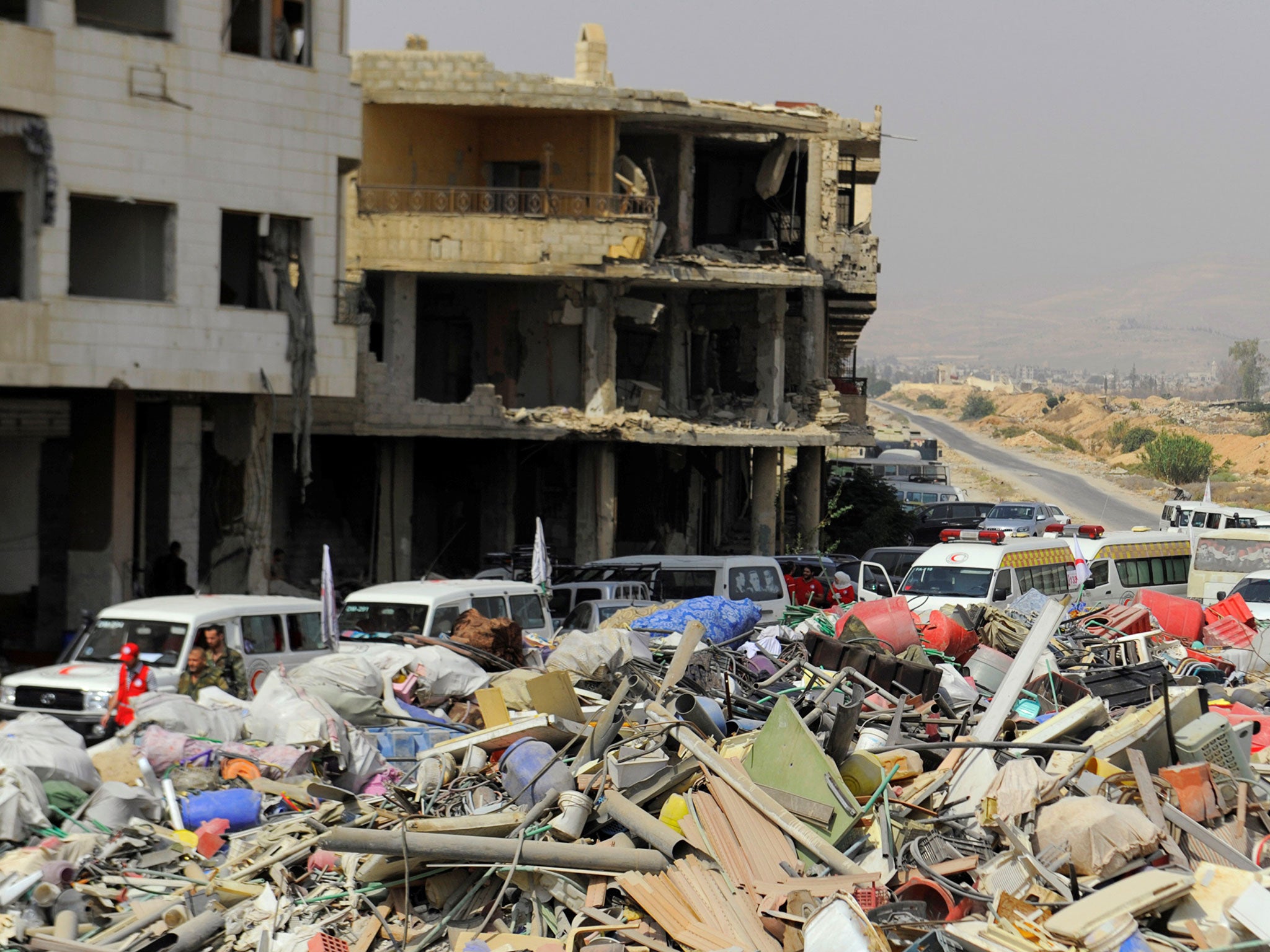 A Syrian Arab Red Crescent convoy waits at the entrance of Daraya ahead of the evacuation on 26 August